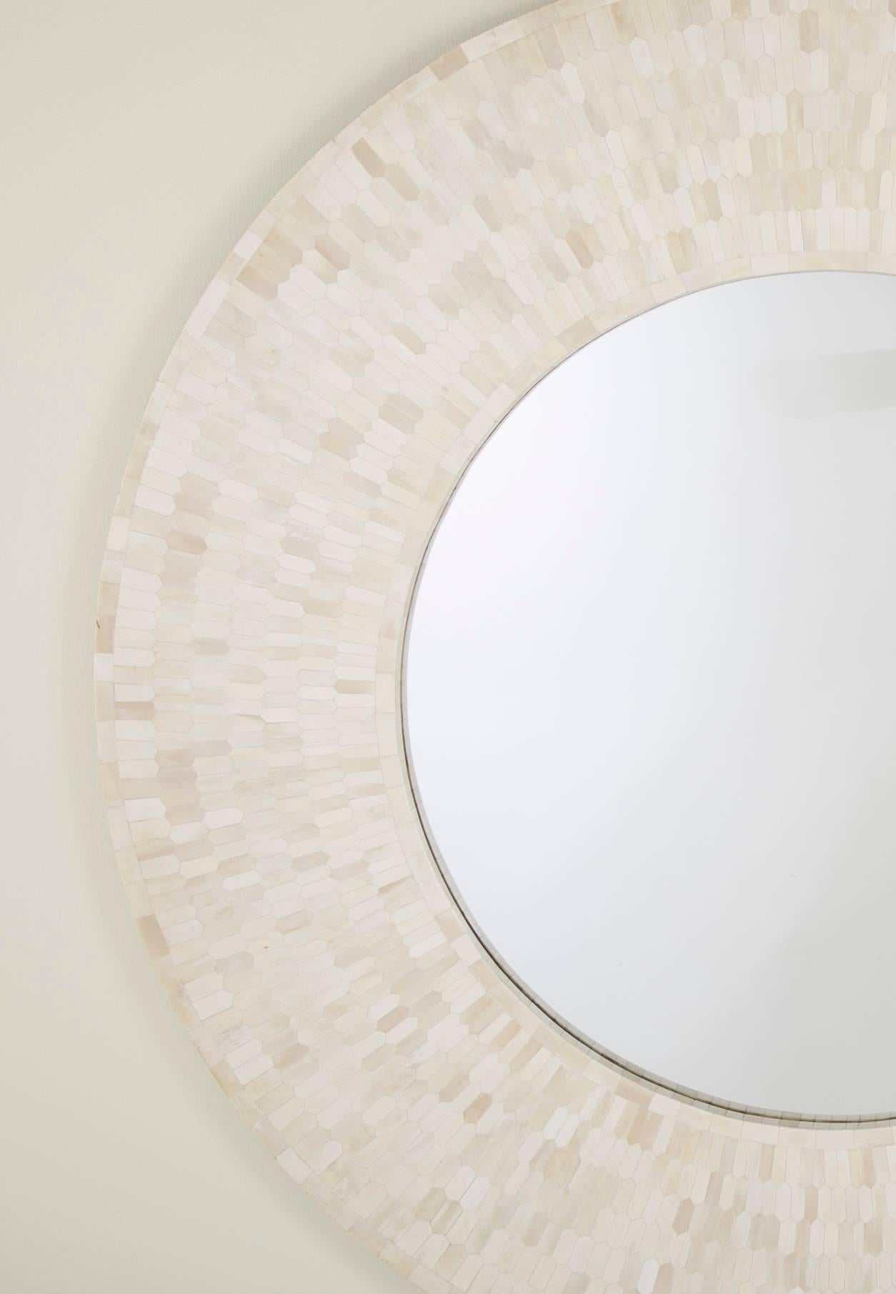 Stunning round mirror of tessellated bone designed by Enrique Garcel. The hexagonal and rectangular bone pieces of slightly variegated color adding texture and depth to this piece. 
The mirror has great scale at 48 inches diameter.