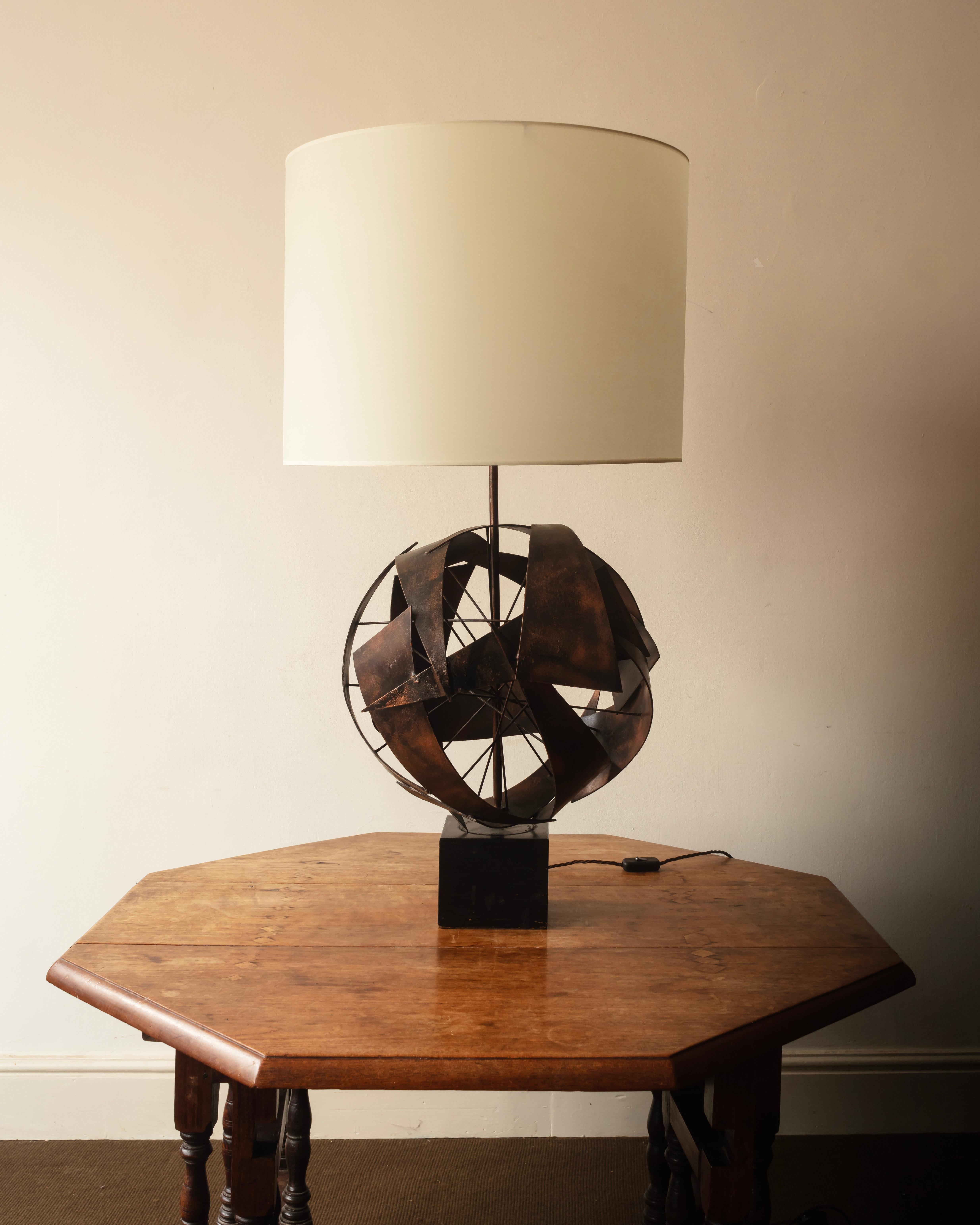 Large scale lamp, the ebonised wooden base supports a sphere made from triangles of patinated steel on a wire armature. French 1960s.

Height: 105 cm to top of shade.
With a custom shade and rewired to UK Standards.