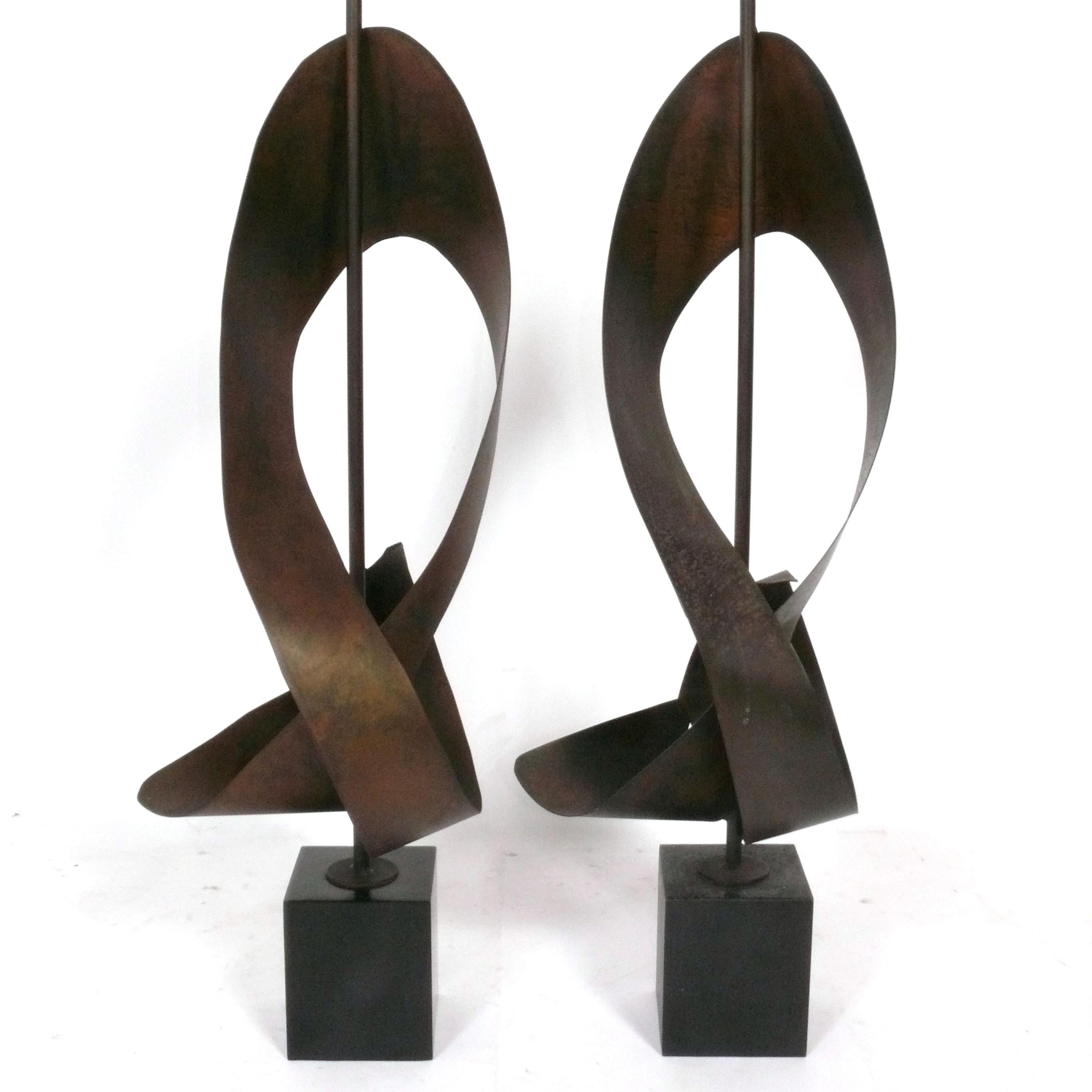Paire de lampes à ruban sculpturales de grande taille, conçues par Harry Balmer pour The Laurel Lamp Company, américaines, vers les années 1960. Ils sont constitués de rubans métalliques en finition bronze patiné et de bases en métal émaillé noir.