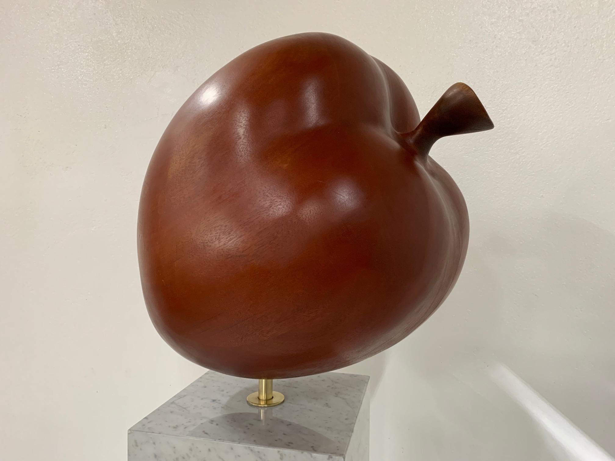 Decorative, large-scale teak apple sculpture on a Carrara marble pedestal. Has a solid brass connector which holds the apple to the marble. The apple is made of solid teak planks.
Sculpture measures (in its entirety) 54.5 H x 21 W. Marble base