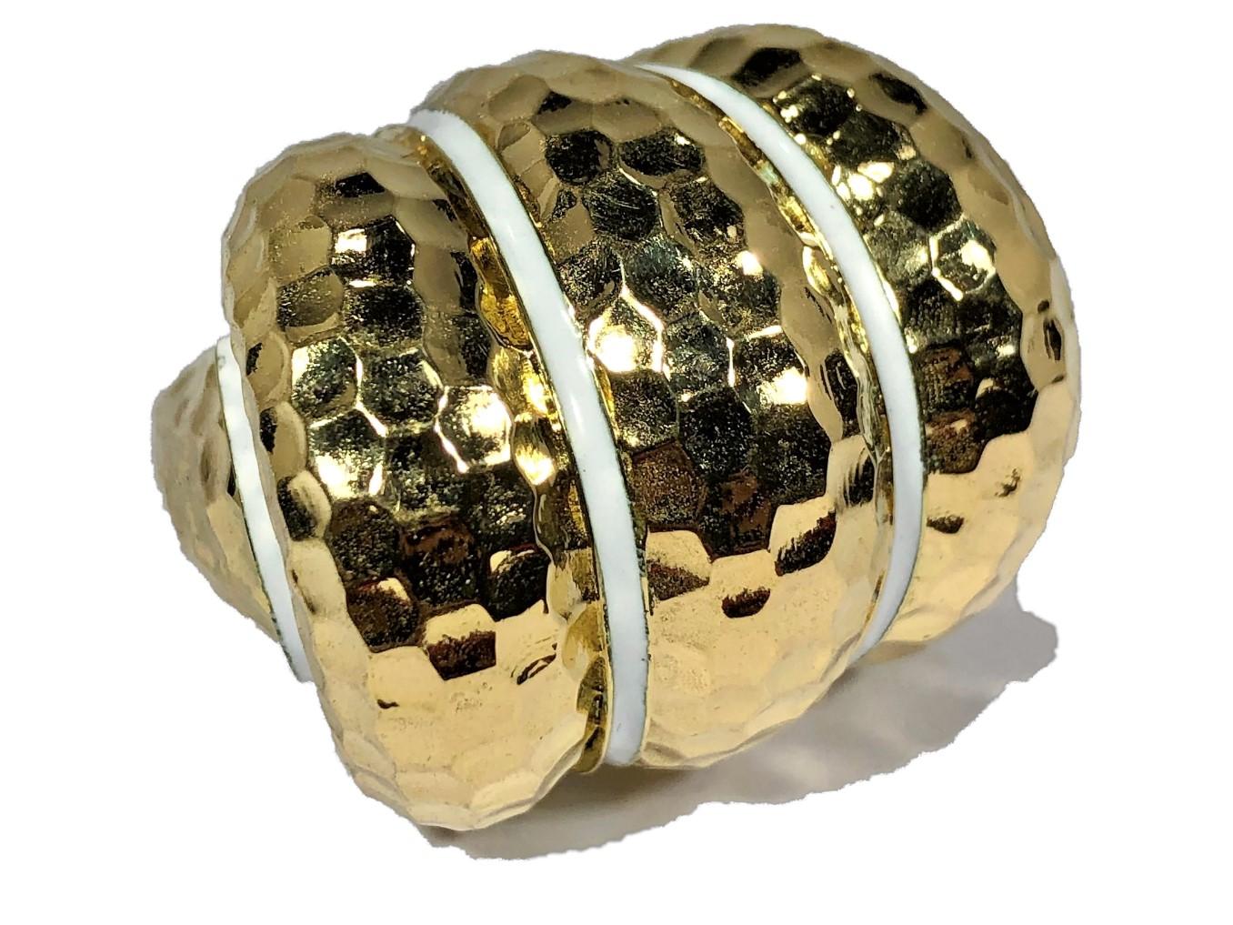 This large and chunky, hammered finish, three section bombee ring is crafted from 18k yellow gold, and has four discreet lines of white enamel which delineate the design area as well as the shoulders. Although newly manufactured it is typical of