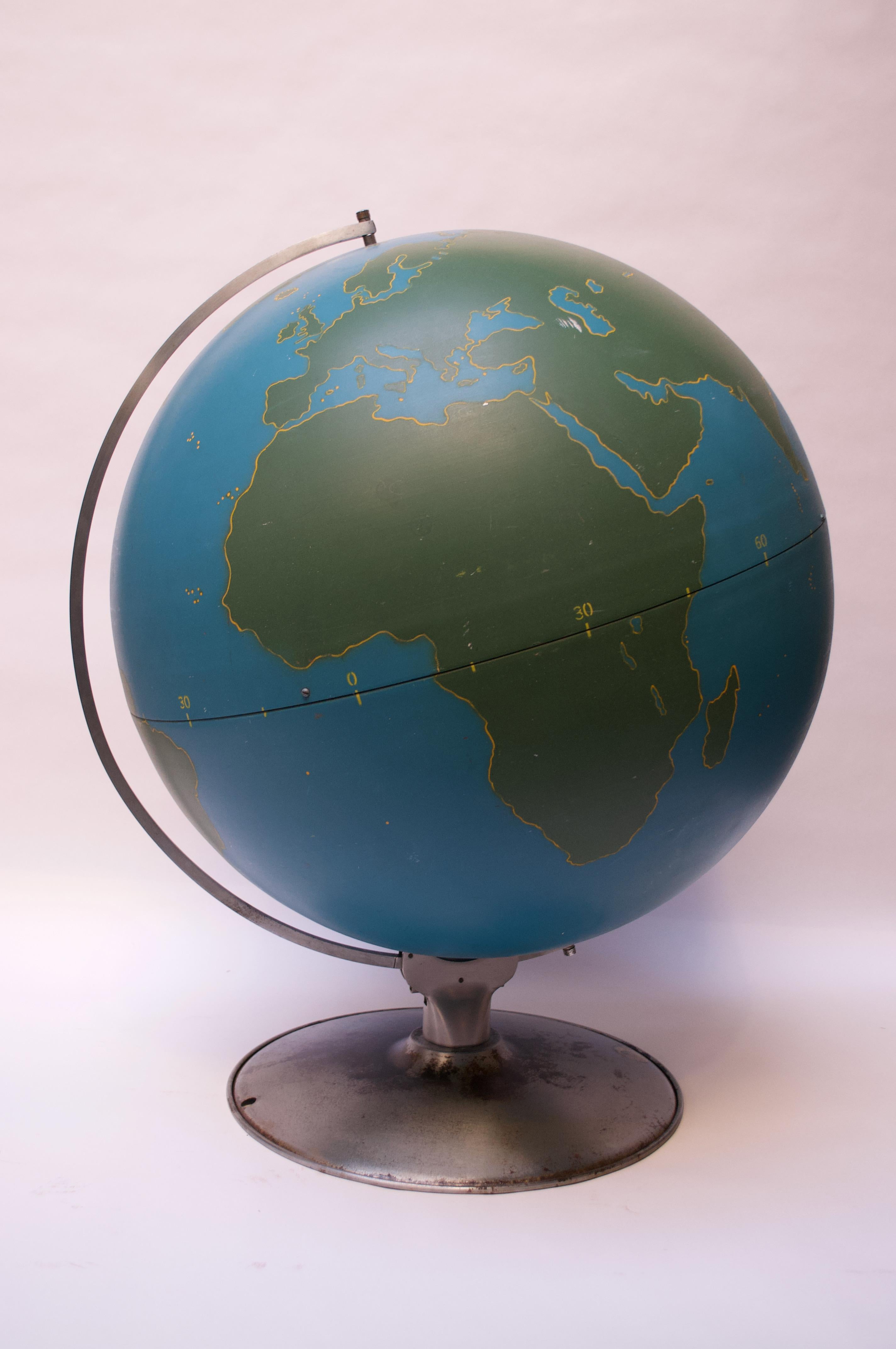 Stile Machine Age di A.J. Globo militare o di attività di Nystrom of Chicago composto da un globo di metallo filato blu con masse terrestri verdi delineate in giallo. Questi mappamondi venivano utilizzati dall'esercito e dalla NASA, oltre che come