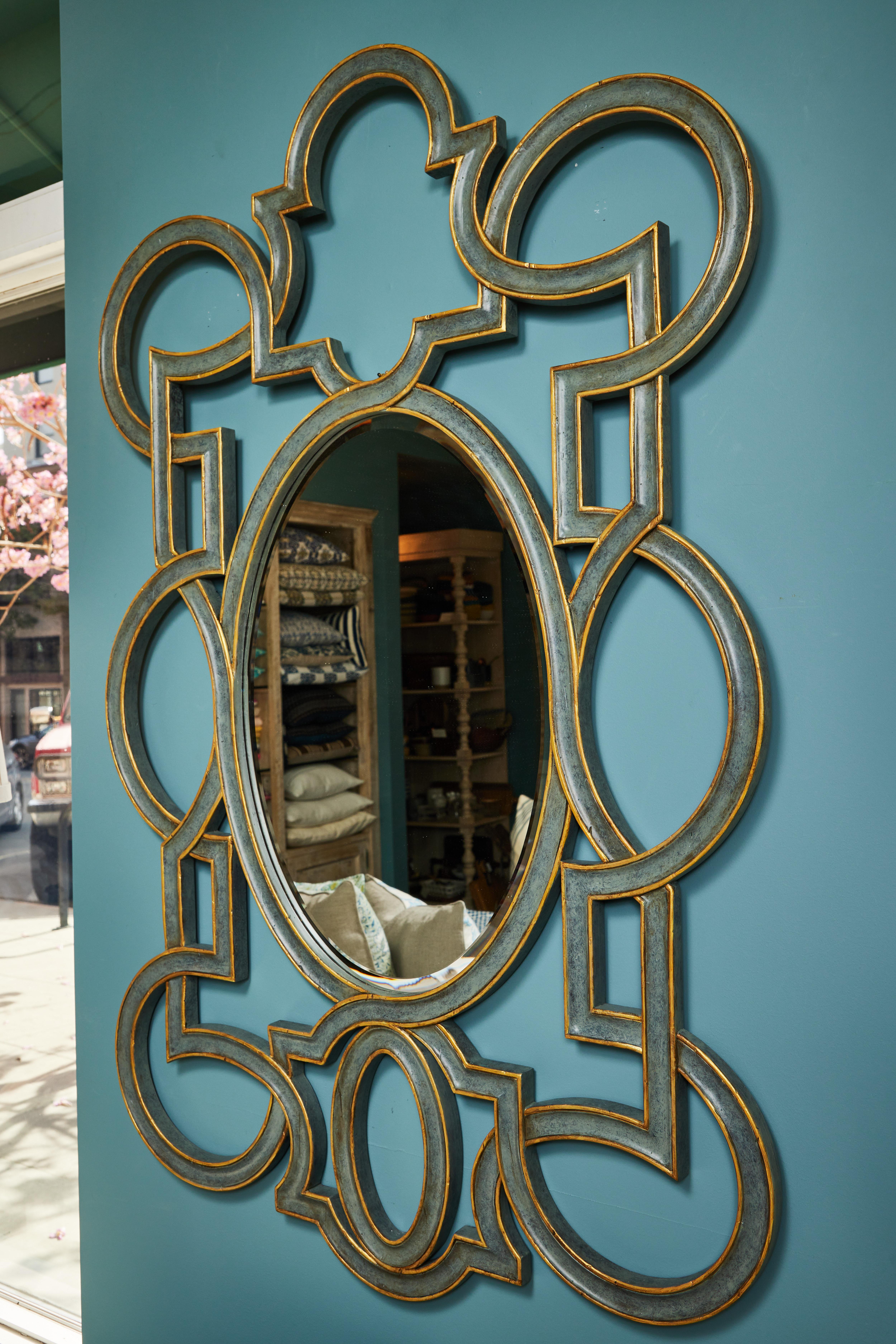 This fantastic large scale vintage mirror has oval beveled center mirror surrounded by an elaborate open fretwork frame. The frame has been newly painted in a distressed blue sage finish with gold detail. 

It measures 58