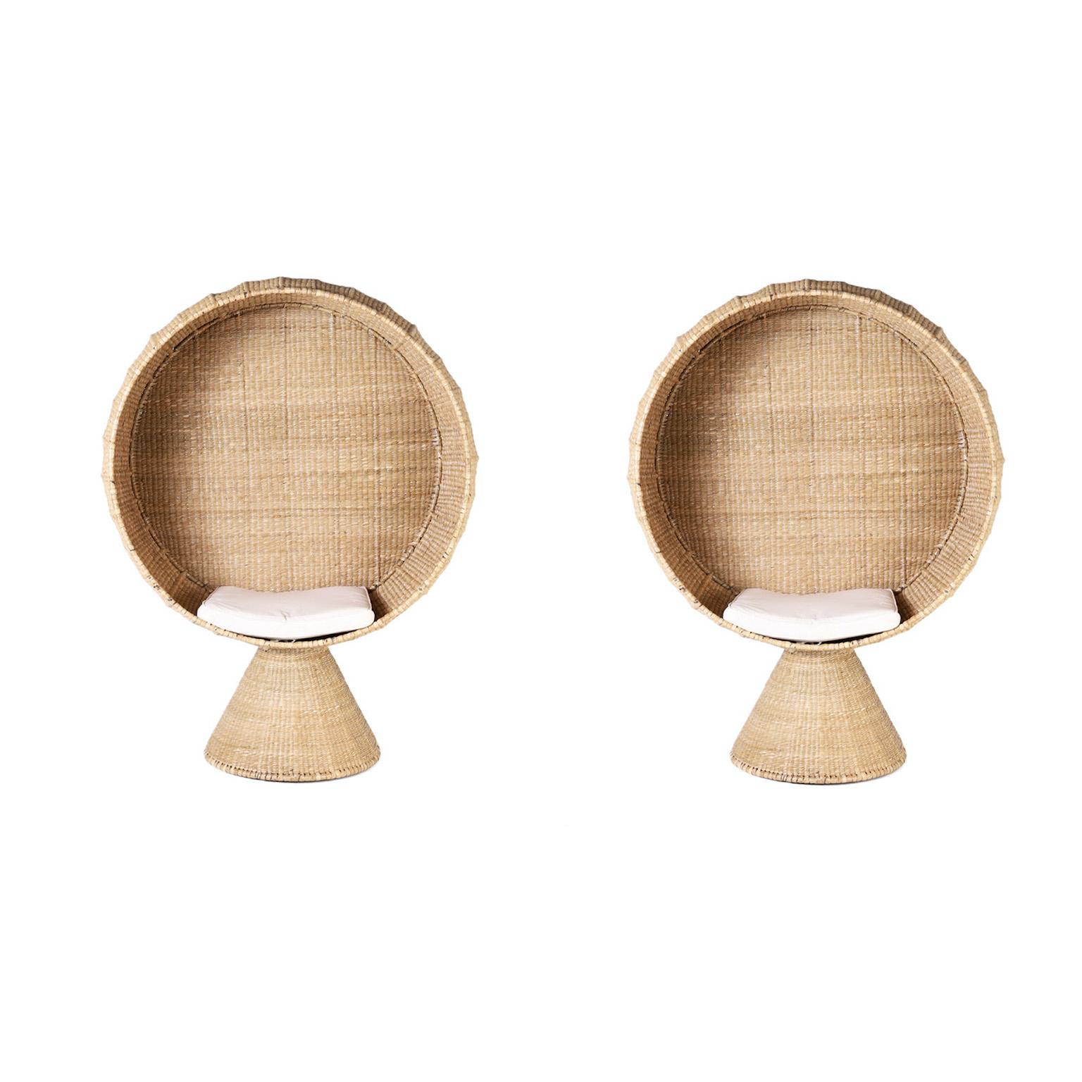 Striking pair of large mid century style chairs hand crafted in reed wrapped over a metal frame in a dramatic spherical form on a tapered pedestal. One of many exciting new designs from the FS Flores Collection designed and offered exclusively by