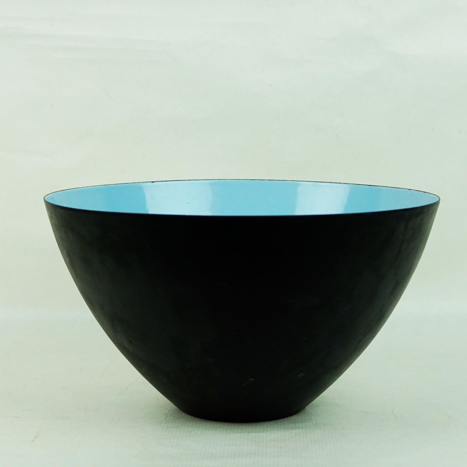 A stylish and large Danish Krenit Turquoise enameled black metal bowl designed by Herbert Krenchel and dating from the 1960's. The bowl stands on a narrow flat rounded foot and is of deep rounded form with the inner bowl decorated in bright