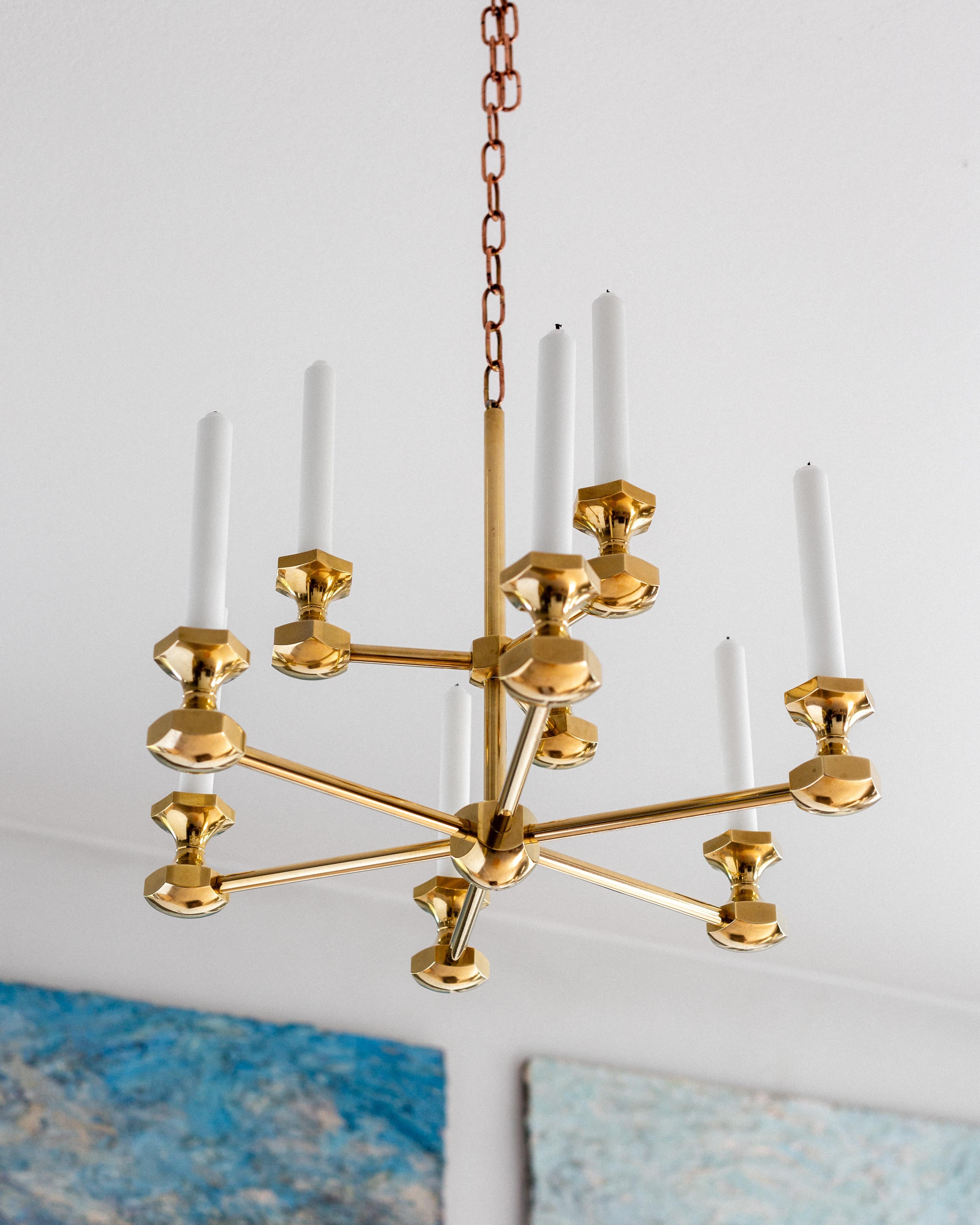 Grande e pesante lampadario in ottone che si fa notare per le sue dimensioni e la sua presenza. Realizzato in ottone massiccio nel 1980 dal designer Bernt Karlsson per Gusum, un'azienda svedese fondata nel 1661 e dedicata esclusivamente alla