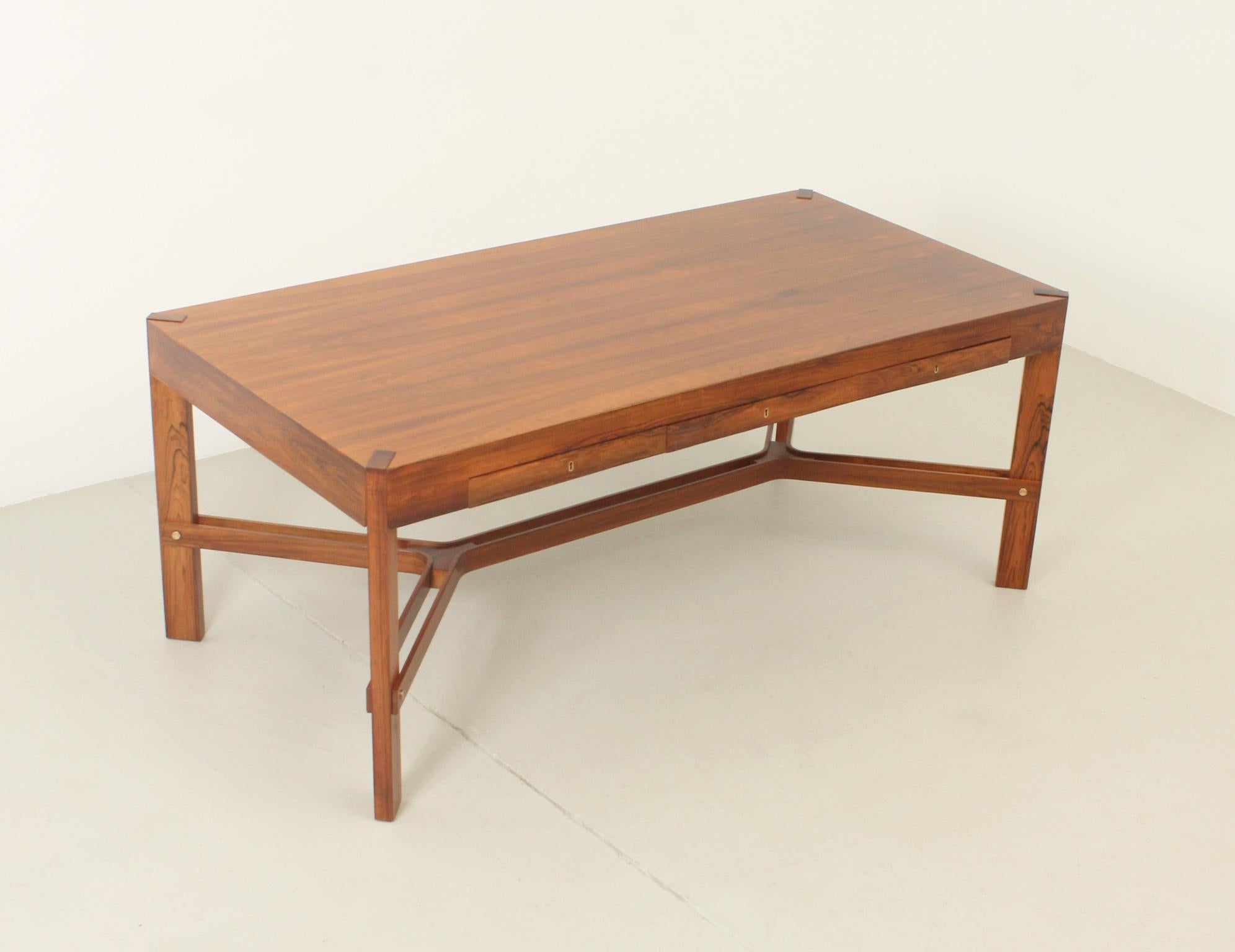 Grand bureau scandinave des années 1970 en bois de rose et bocote avec trois tiroirs et des ferrures en laiton. 