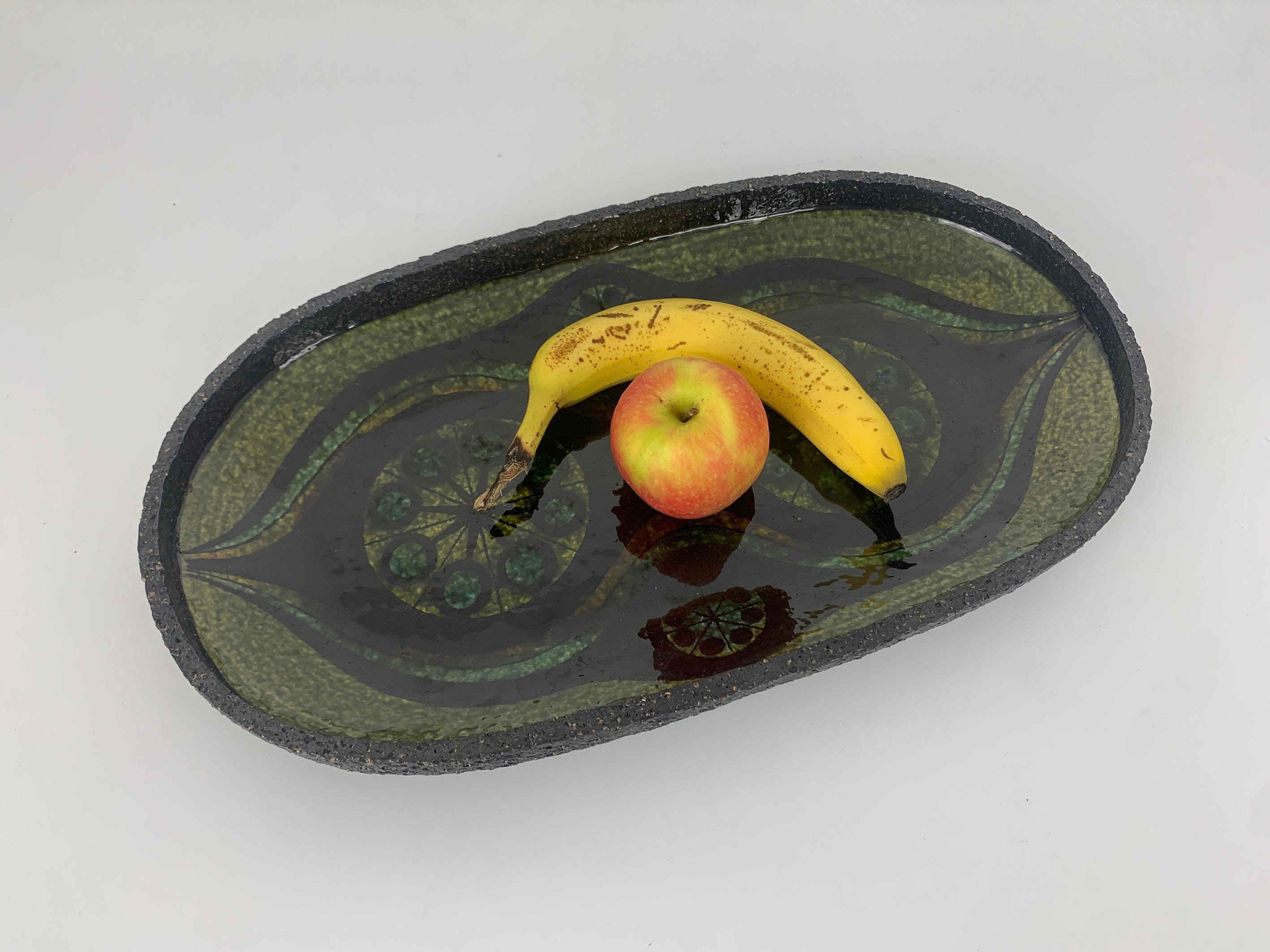 Big oblong low stoneware bowl or centerpiece made in Denmark. Created by Danish ceramist Thomas Toft in the 1950s or 1960s. 

It has a glazed inside and a rough textured exterior. The rough dark brown chamotte clay on the outside contrasts with the