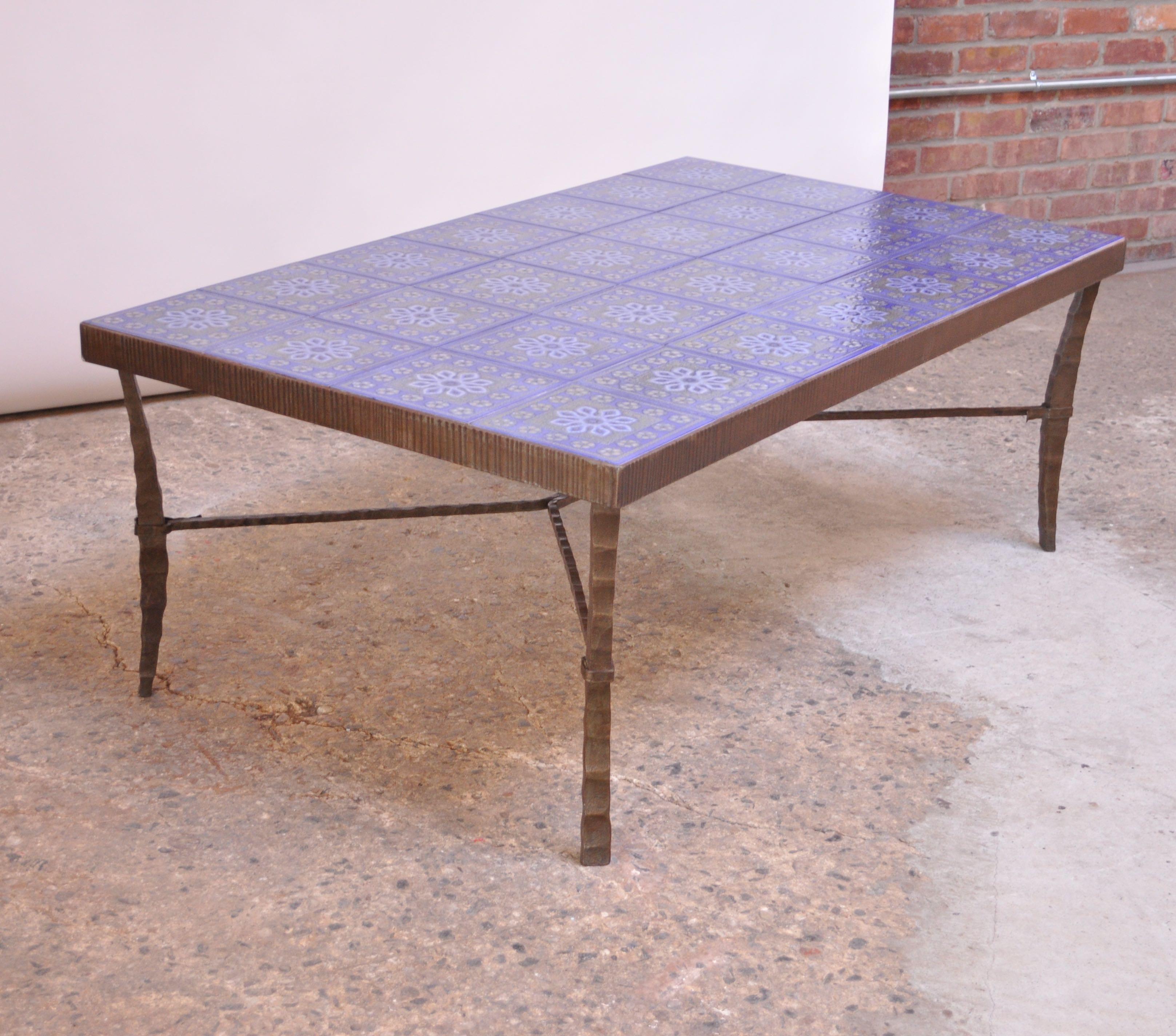Monumental and masterful circa 1960s Scandinavian coffee table composed of a hammered / sculpted bronze frame with inset ceramic tiles in indigo with a snowflake or floral motif throughout. Color is a purple-blue, but deceptively appears more blue