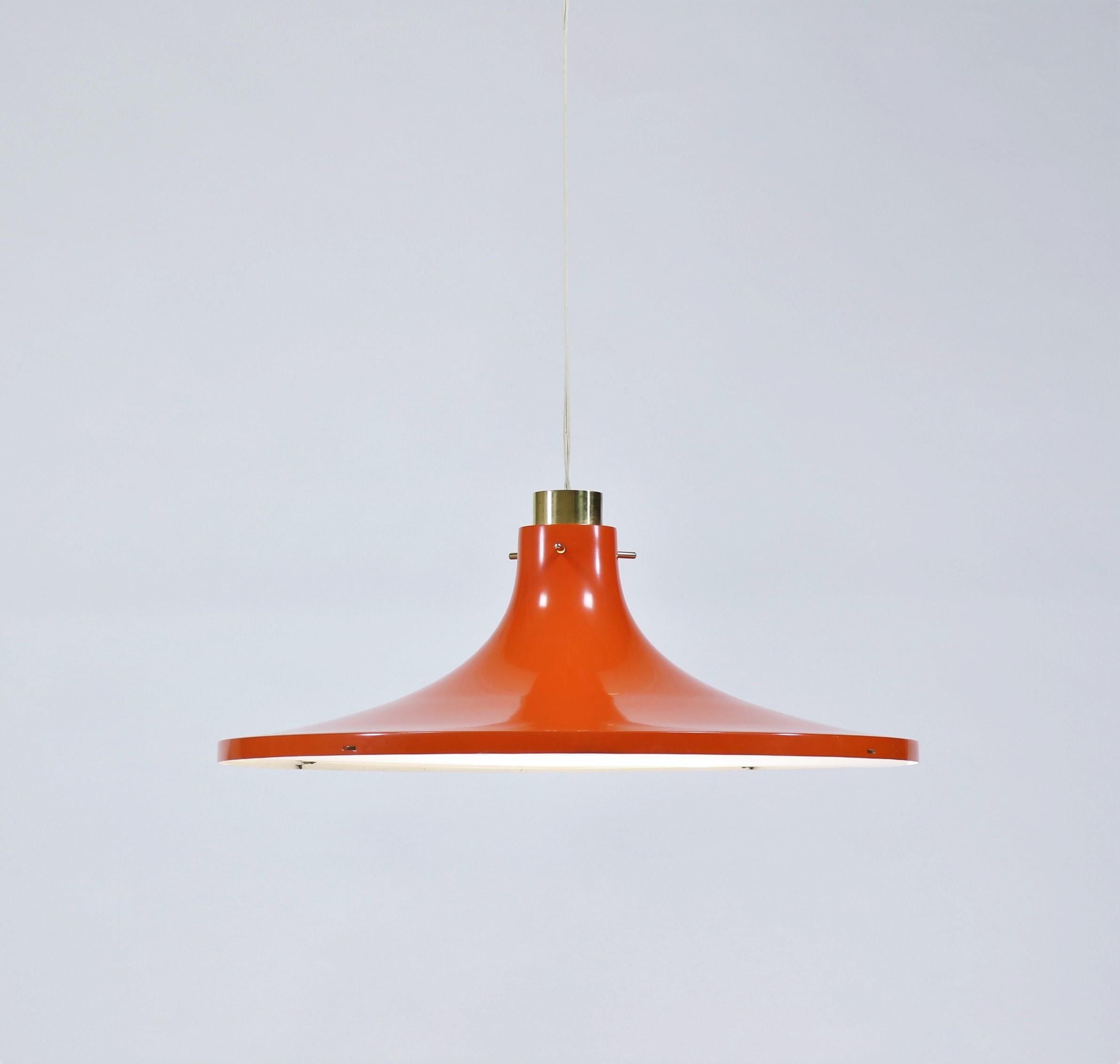 This stunning pendant was designed by Hans Agne Jakobsson in the 1960s and manufactured by Hans Agne Jakobsson AB in Markaryd, Sweden. It is made from an orange tulip formed shade with an elegant brass fixation at the top. The light comes with its