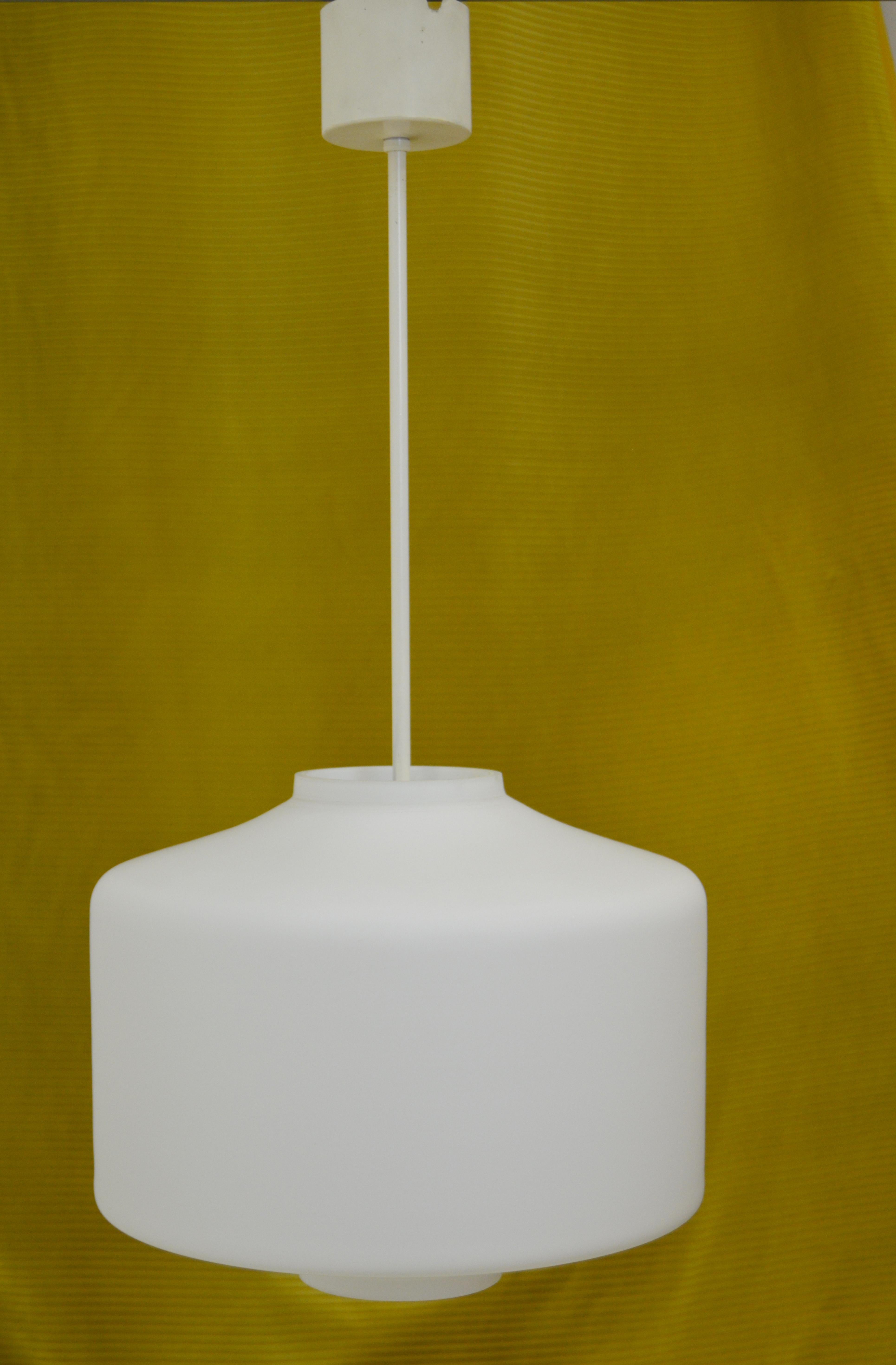 This lamp was made in the 1950s and is in a great vintage condition. It features a large opaline glass cylinder that rests on three metal holders that are mounted in a white metal bar. 

Most likely manufactured by ASEA in Sweden, were designers