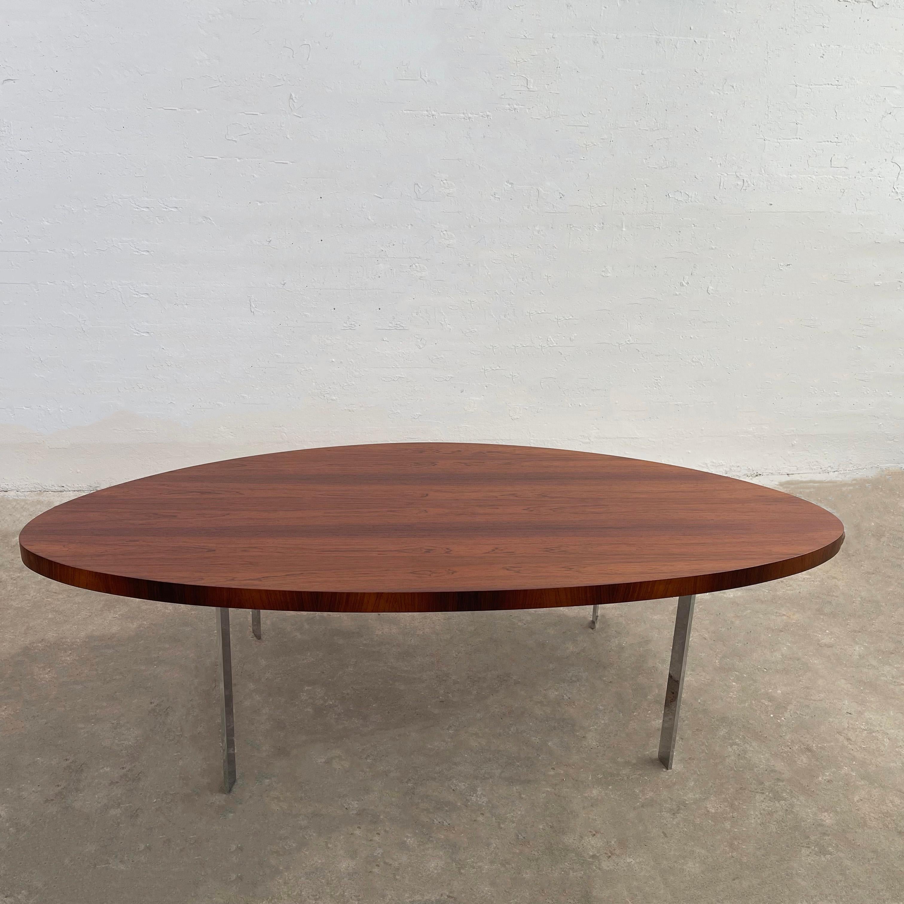 Large, Scandinavian modern, coffee table circa 1970's features a peaked oval or rounded triangular shaped, rosewood top with beautiful grain on angled, flat bar chrome legs. It's a uniquely shaped table that offers design flexibility.