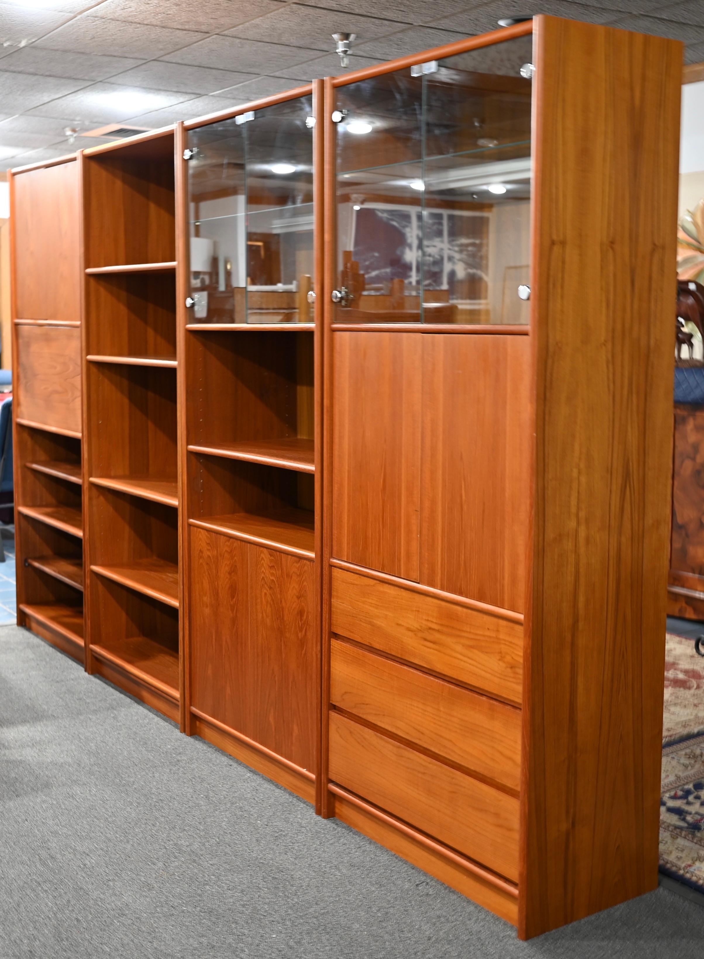 A large and very good quality vintage Scandinavian Modern teak 4-part bookcase, display cabinet, dry bar or secretary made in Denmark. 

This fine Scandinavian Modern style is comprised of 4 separate pieces. All are the same depth, width and height.