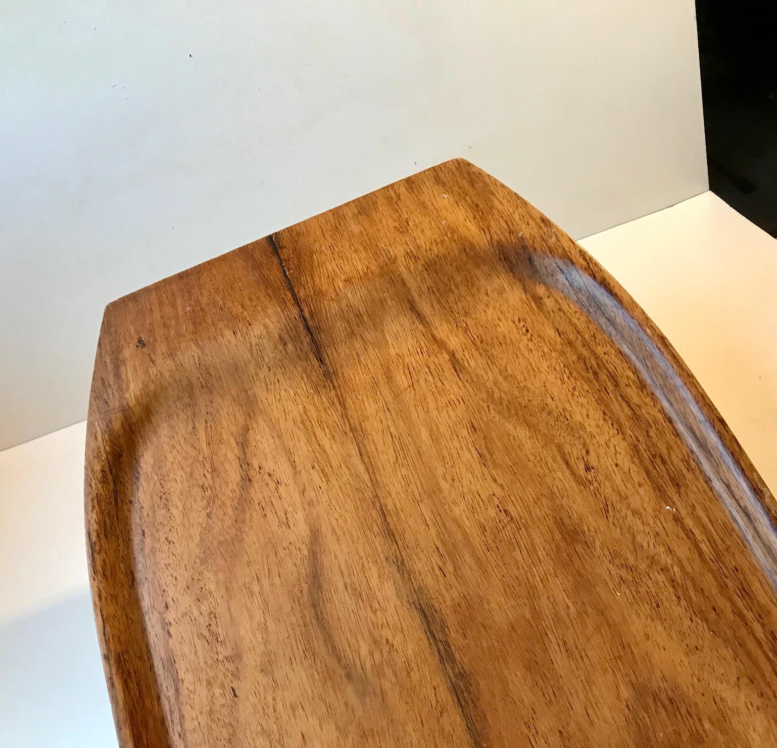 Large oblong serving tray made from rosewood veneer (East Indian Type). Suitable as a bed serving tray due to its size and raised edges. It was made in Denmark during the 1960s by Åry. Measurements: 60.5x32x3 cm.