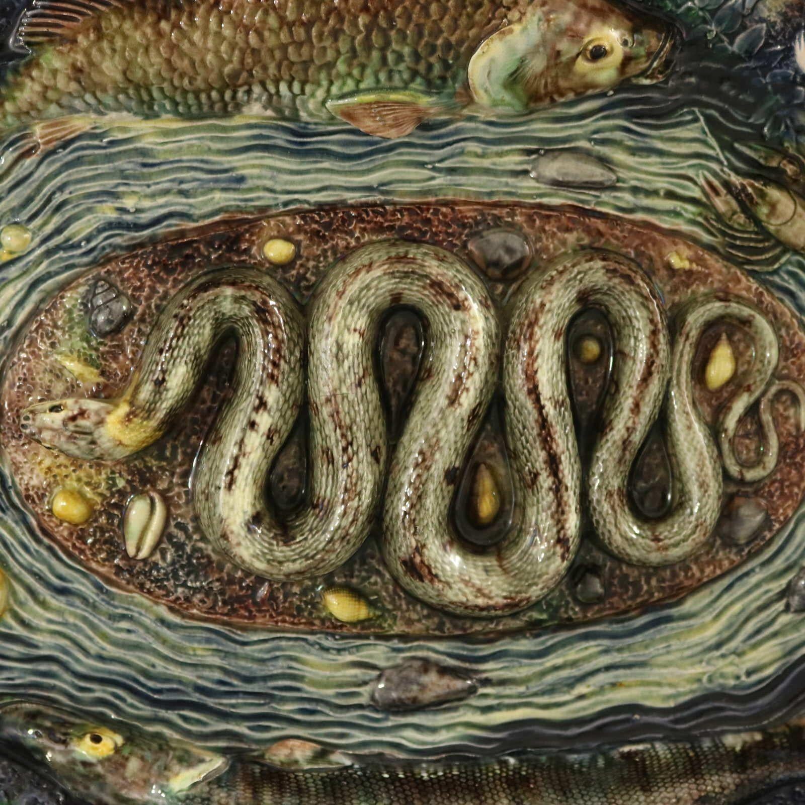 School of Paris French Palissy Majolica wall platter which features fish (a carp, a pike), a snake, a frog, langoustines, insects and shells. Rippled water-effect ground. Colouration: blue, green, grey, are predominant.