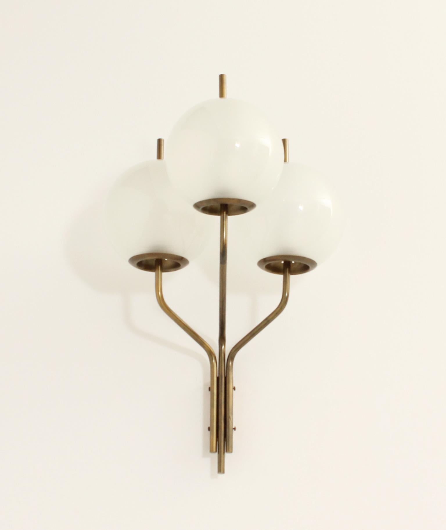 Grande applique triple produite dans les années 1960 par Candle Milano, Italie. Trois bras en laiton avec trois globes en verre de Murano de 24 cm de Ø chacun. 