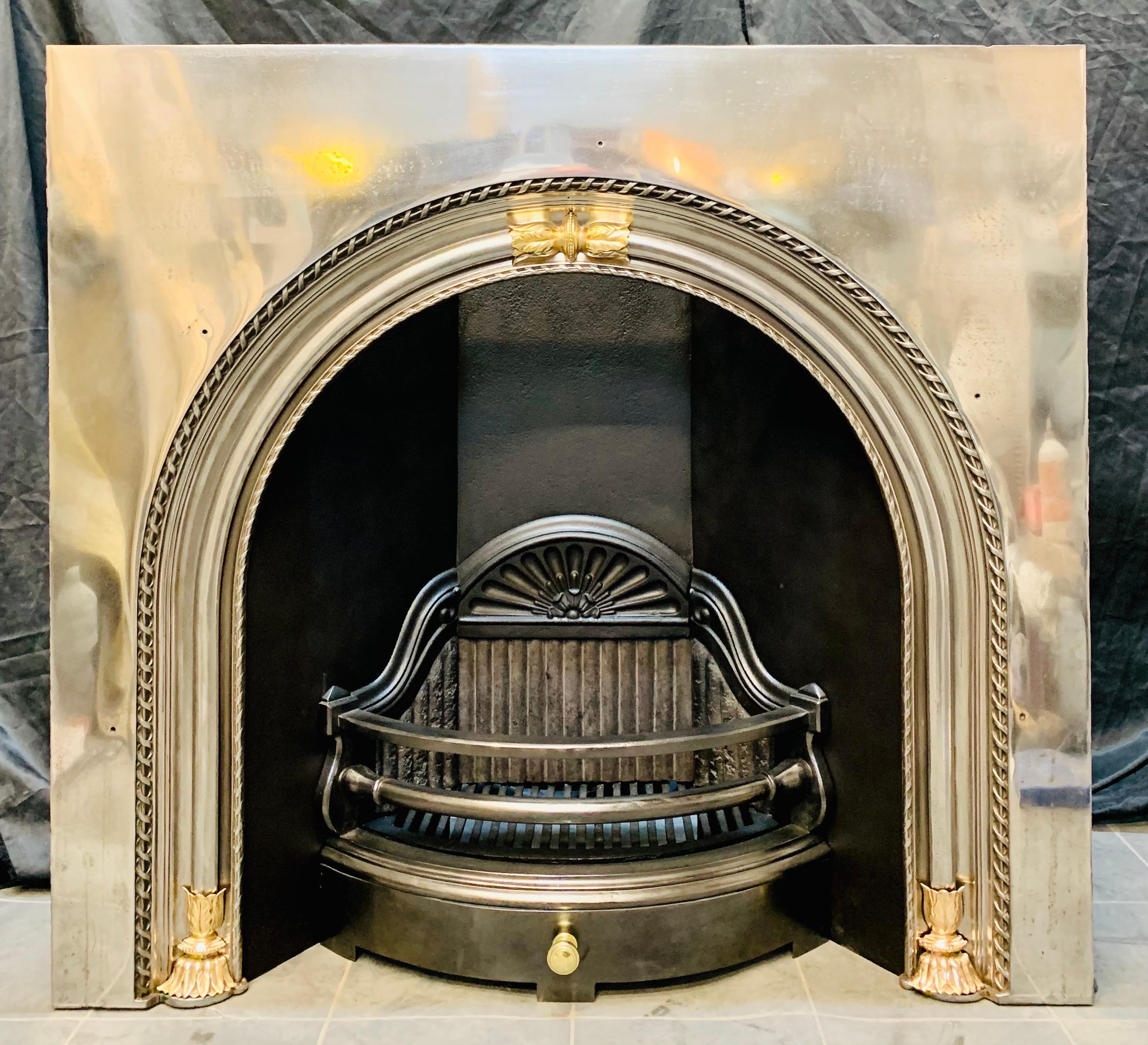 A large, Probably Scottish, 19th century mid Victorian arched fireplace insert with applied brass embellishments. 
A wide and generous polished outer plate, with a raised decorative arched border displaying good crisp casting. The central arch is
