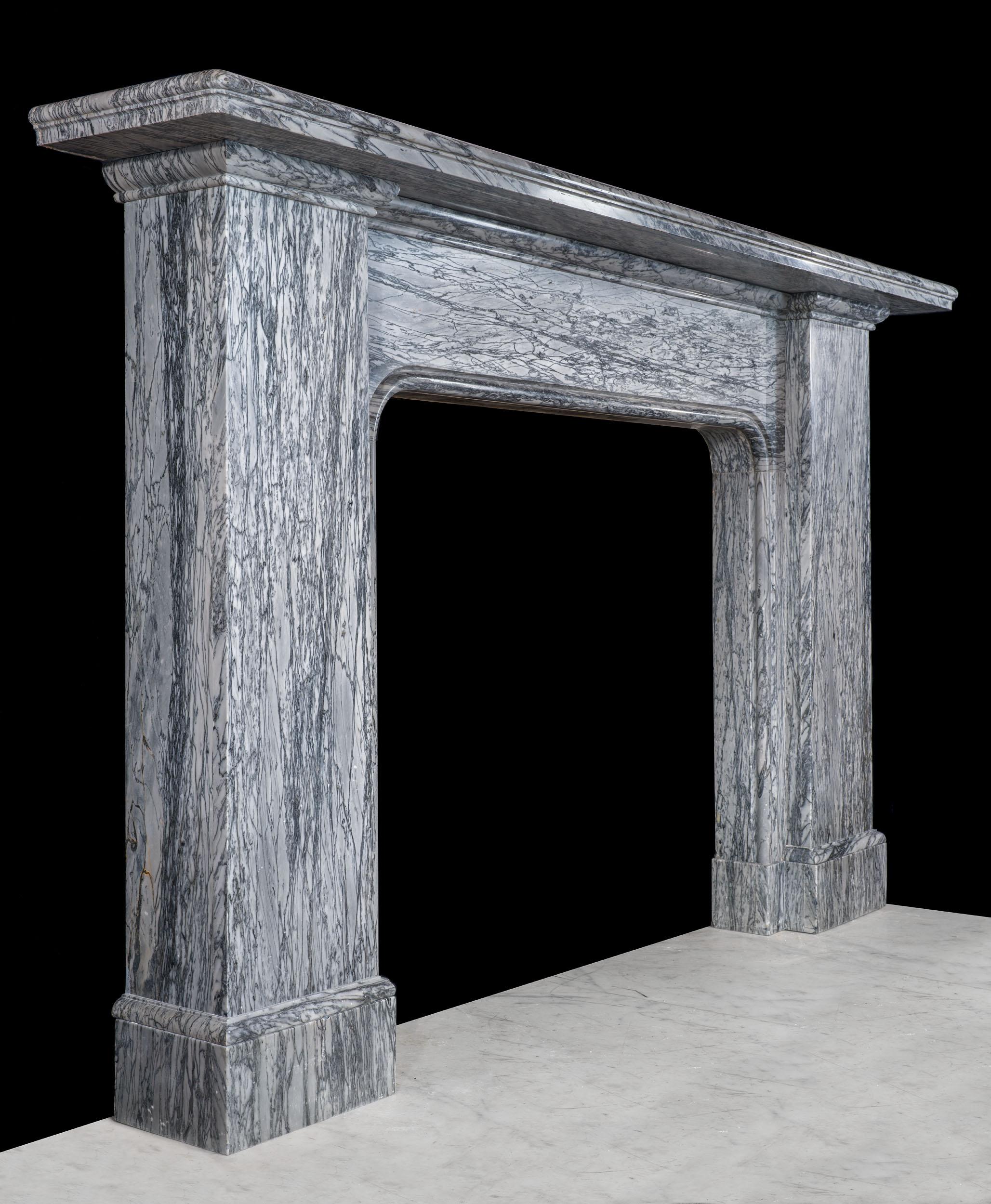A very fine chimneypiece with a striking simplicity of form, reminiscent of the work of Sir John Soane.Carved from dramatic dove grey Bardiglio Fiorito marble, the wide stepped shelf rests on two monumental jambs, which flank a large opening. One of