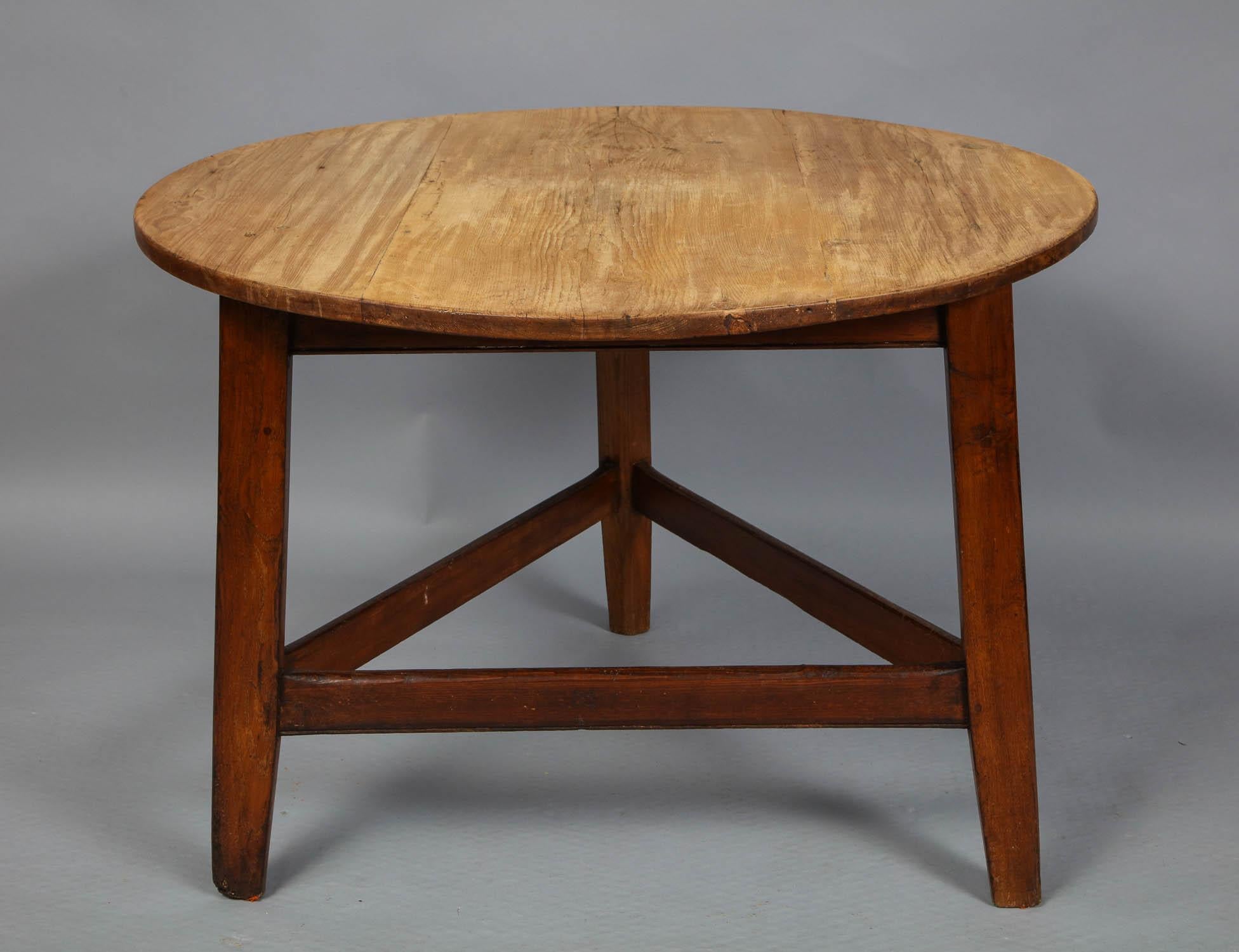 Unusual English or Welsh cricket table having a single board pine top over oak base having splayed tapered legs joined by box stretcher and retaining traces of original red wash, the top with lovely scrubbed surface. This cricket table is larger