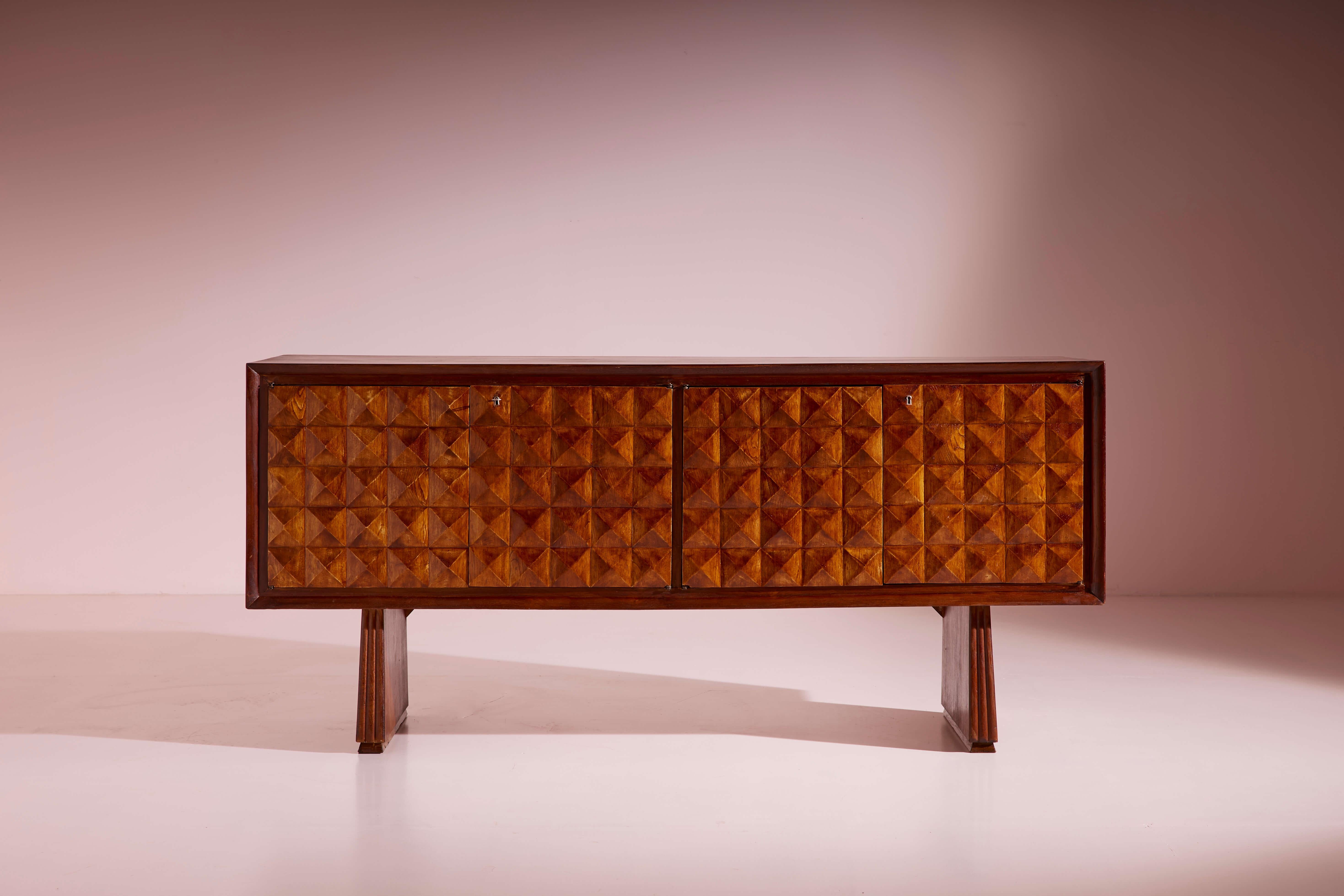 Grand buffet en bois massif à quatre portes sculptées, dans le style de Paolo Buffa, fabrication italienne, années 1940

Le grain de bois frappant qui traverse horizontalement la pièce, associé aux lignes géométriques épurées typiques du design des