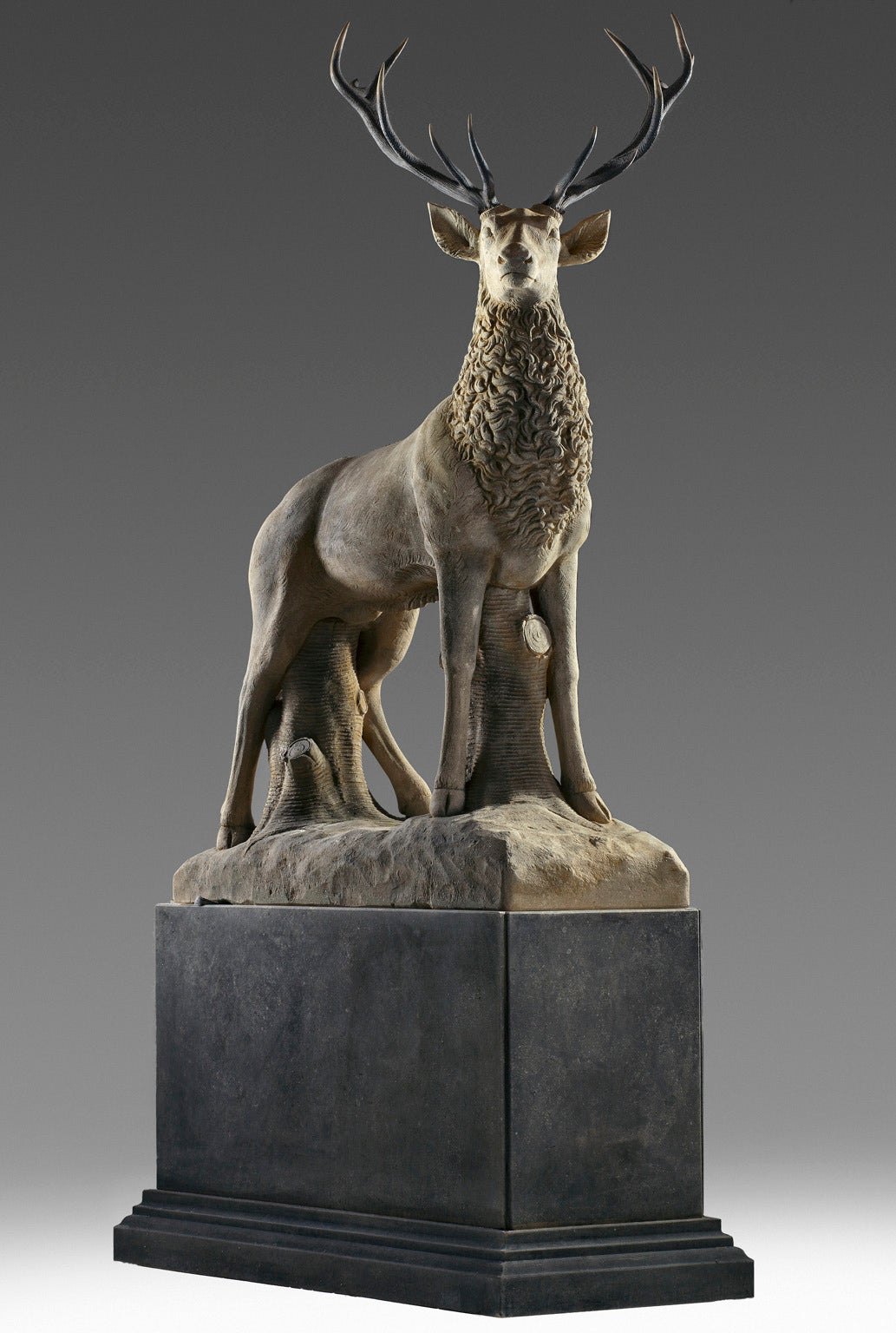 Large sculpted limestone and antler mounted model of a stag / reindeer. Naturalistically modelled standing, above a rectangular section limestone plinth, 325 cm. high overall, the base 100 cm. high.