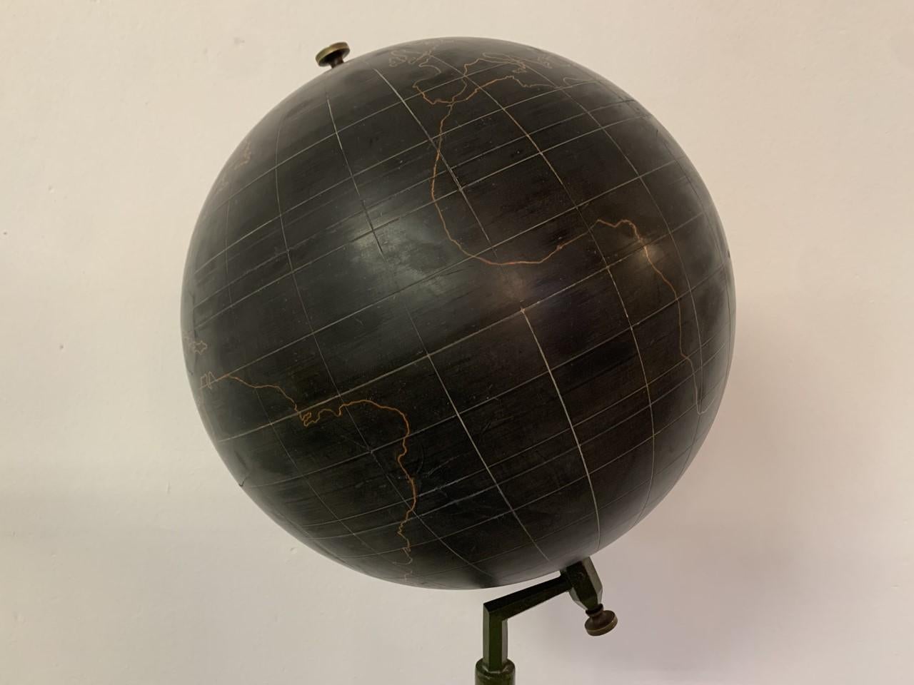 Large Globe floor stand, metal, resin, Belgium, 1950s.

Beautiful globe on a floor stand. The reserved, almost monochromatic color scheme in black and red lining gives the item a sculptural appearance. The strong metal stem on a round base is