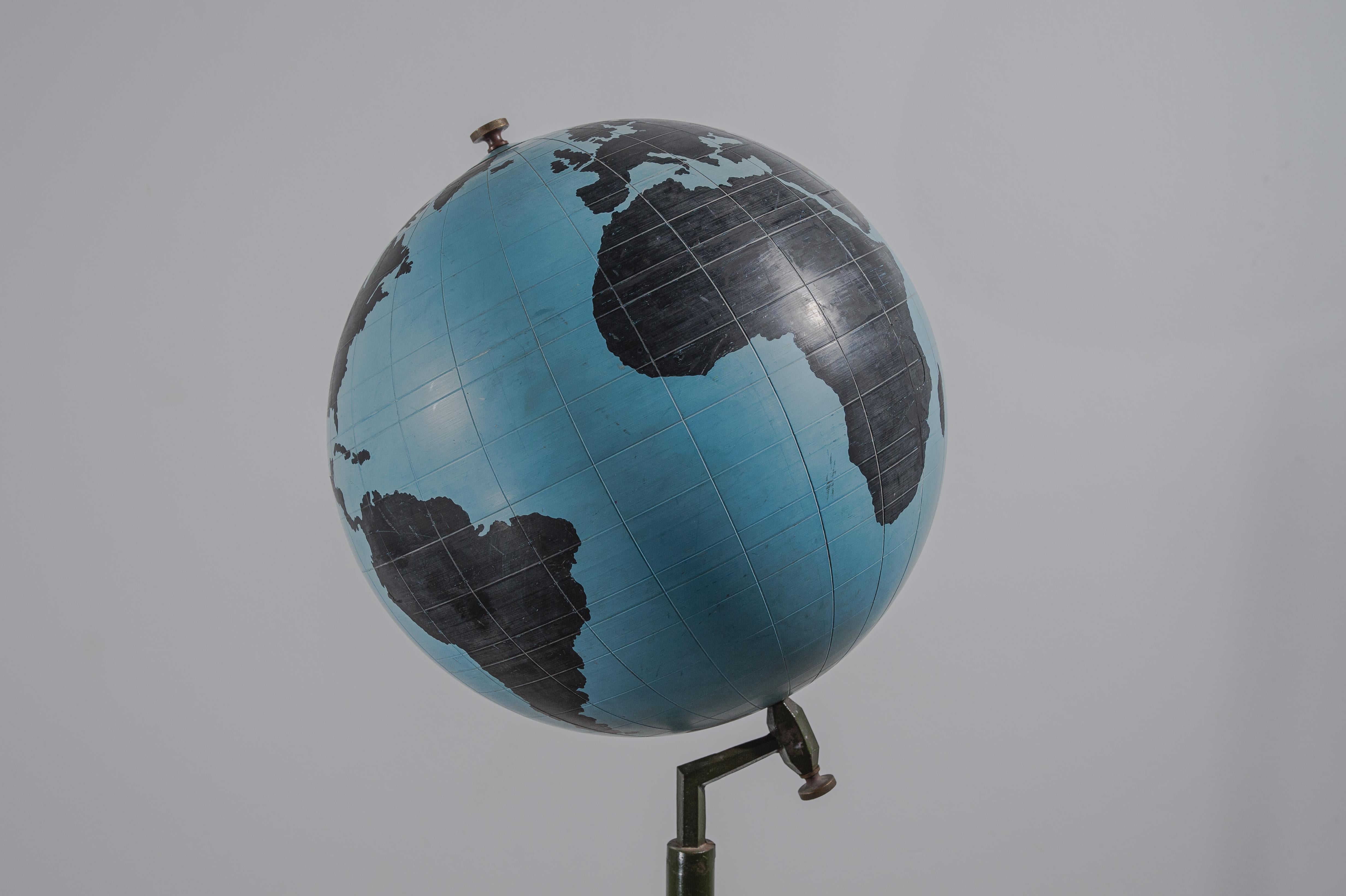 Large Globe floor stand, metal, resin, Belgium, 1950s.

Beautiful globe on a floor stand. The reserved, almost monochromatic color scheme in black and Light Blue gives the item a sculptural appearance. The strong metal stem on a round base is