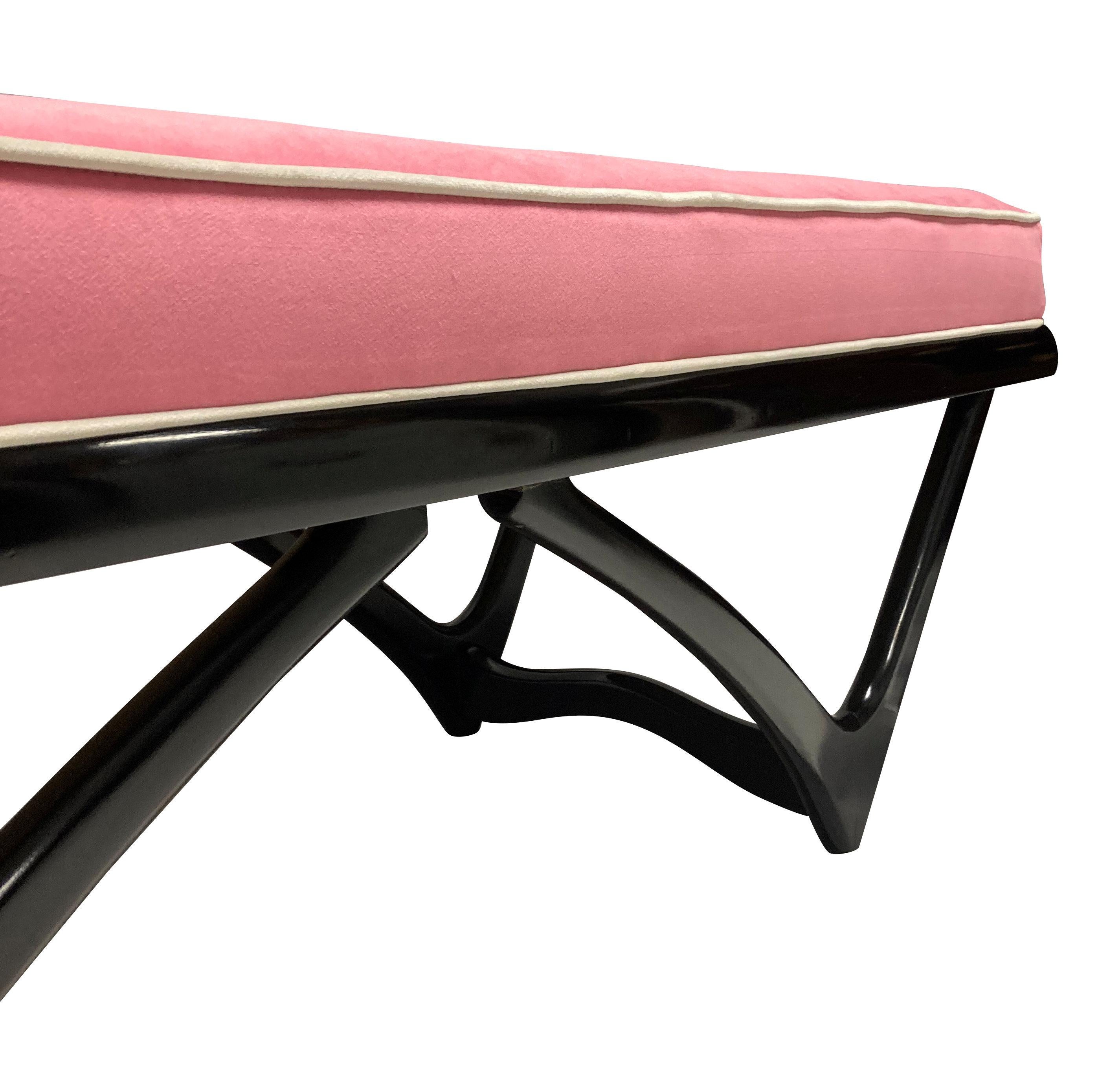 A large Italian Mid-Century bench of sculptural design in the manner of Carlo Mollino. Black lacquered and newly upholstered in bubble-gum pink velvet with cream detailing.