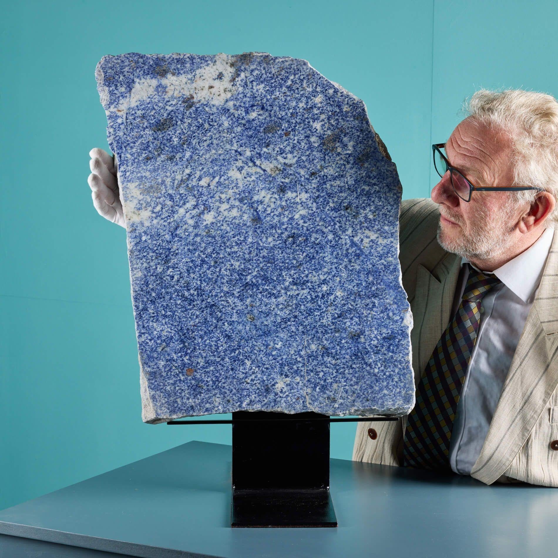 A large sculptural blue sodalite granite specimen with a polished face and a roughly shaped ‘live’ edge. At 56cm in height, this rare, large sized mineral is spectacular in scale, becoming a focal point of a sideboard or collectors cabinet. The face
