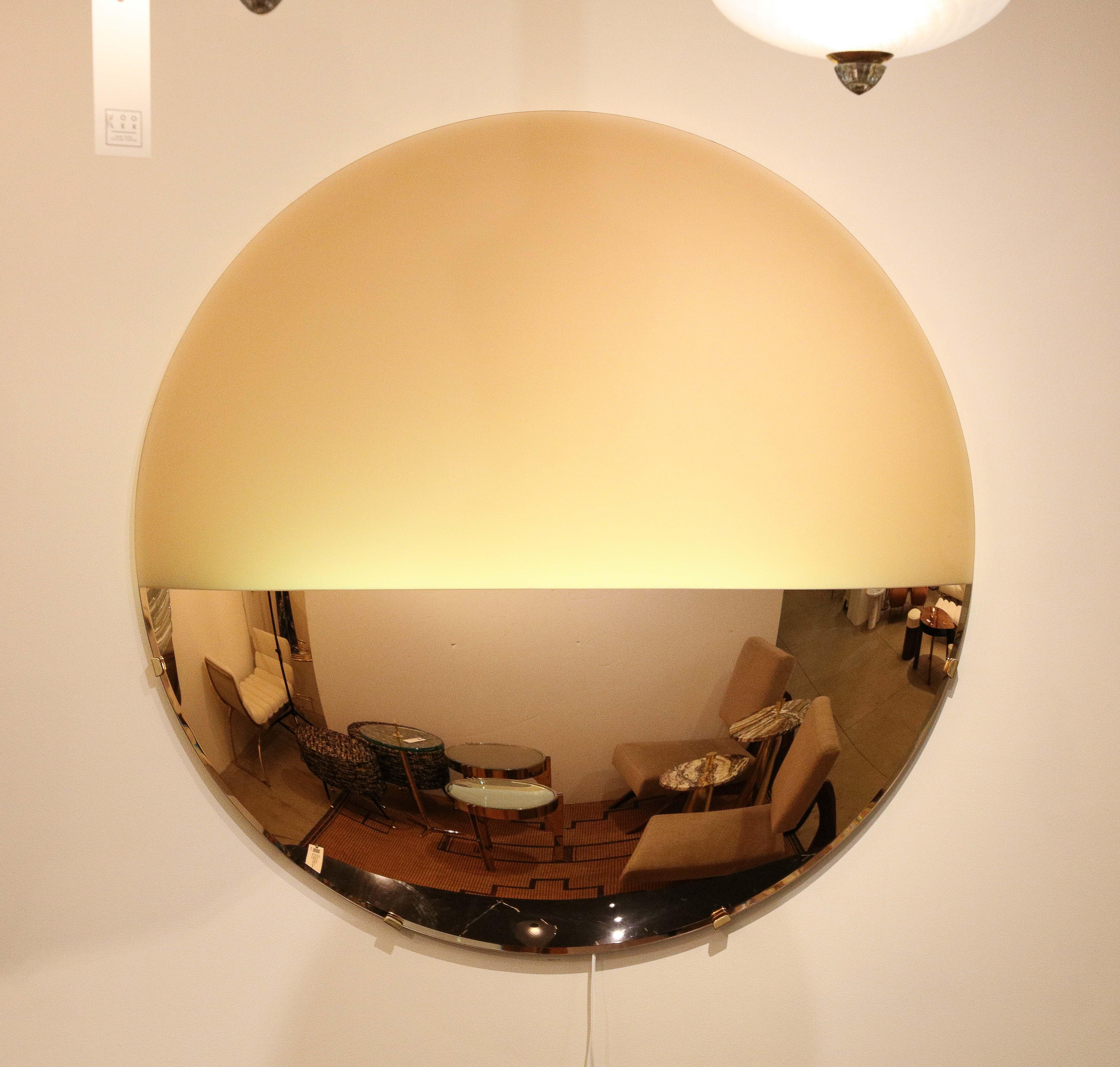 Ce grand miroir sculptural rond convexe en or rose éclairé ou art mural est une œuvre d'art unique.  Un grand verre rond est d'abord thermoformé en une forme convexe sculpturale (c'est-à-dire que la surface ronde s'incurve vers l'extérieur comme