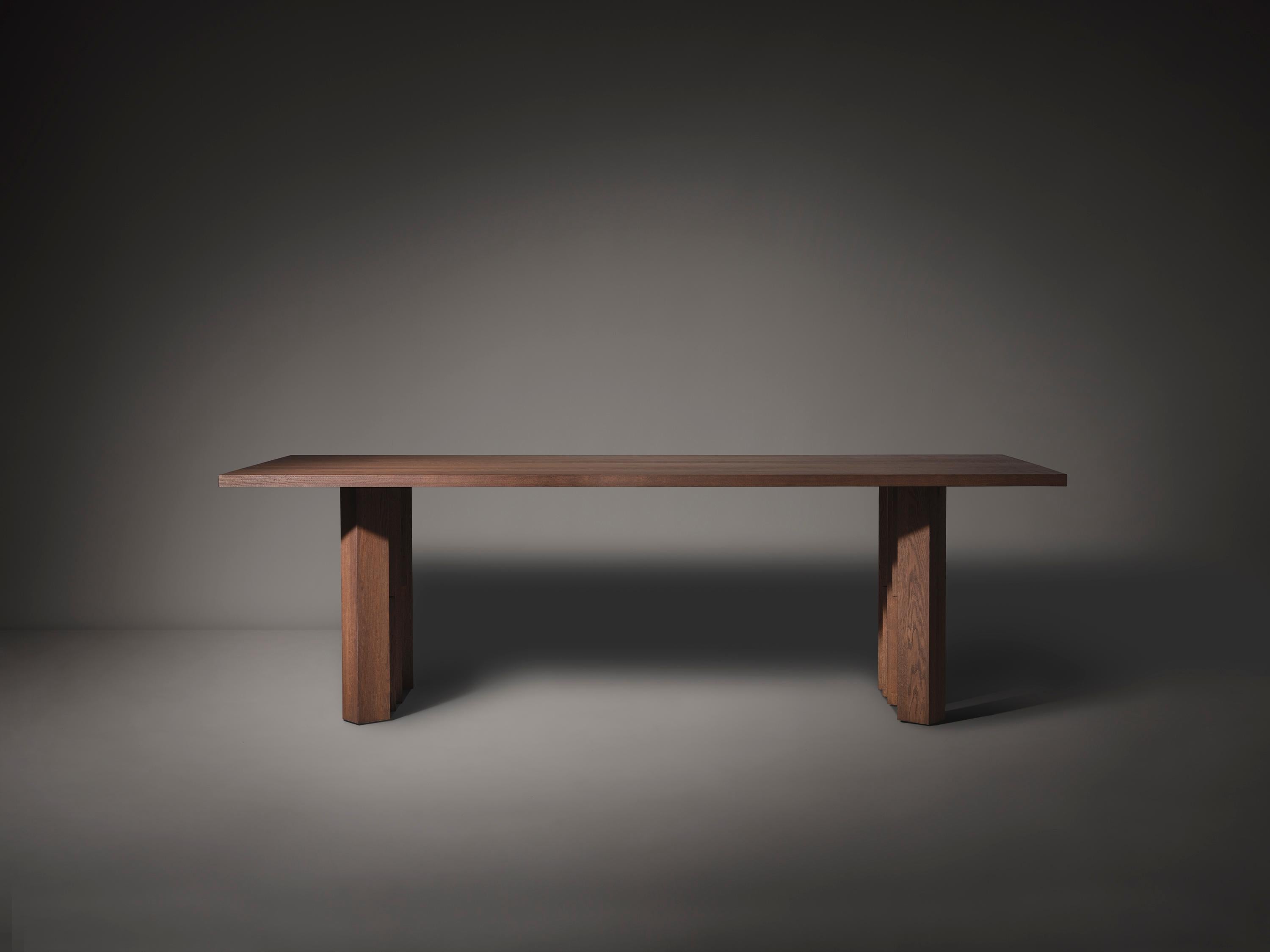 Der vom Stil der Amsterdamer Schule inspirierte Fenestra-Tisch ist aus massivem Hartholz gefertigt und wird nach Maß hergestellt. Der Entwurf ist vom Backsteinexpressionismus inspiriert, der architektonischen Bewegung, die im Amsterdamer 