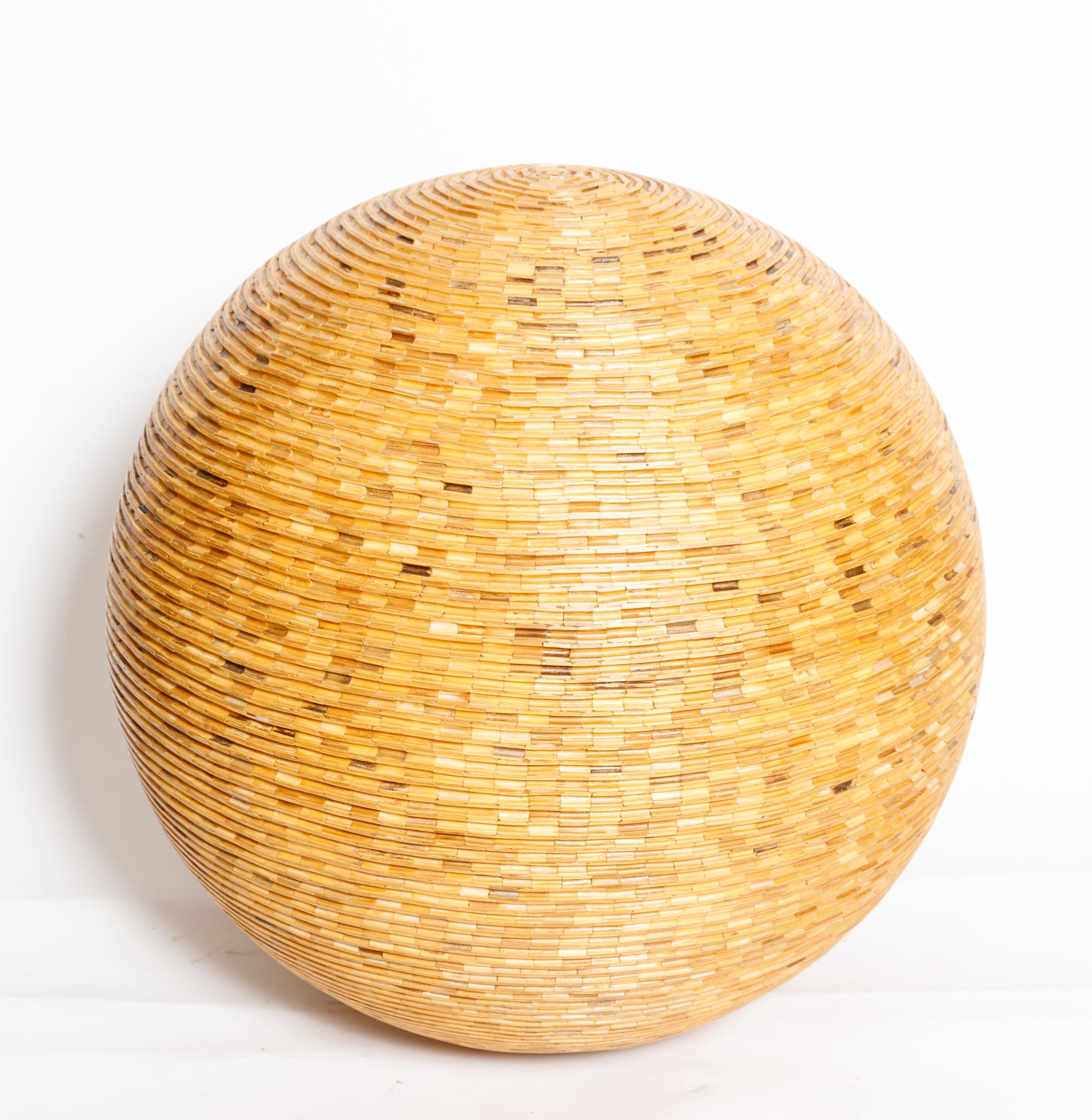 Large sculptural sphere made of wooden pieces.