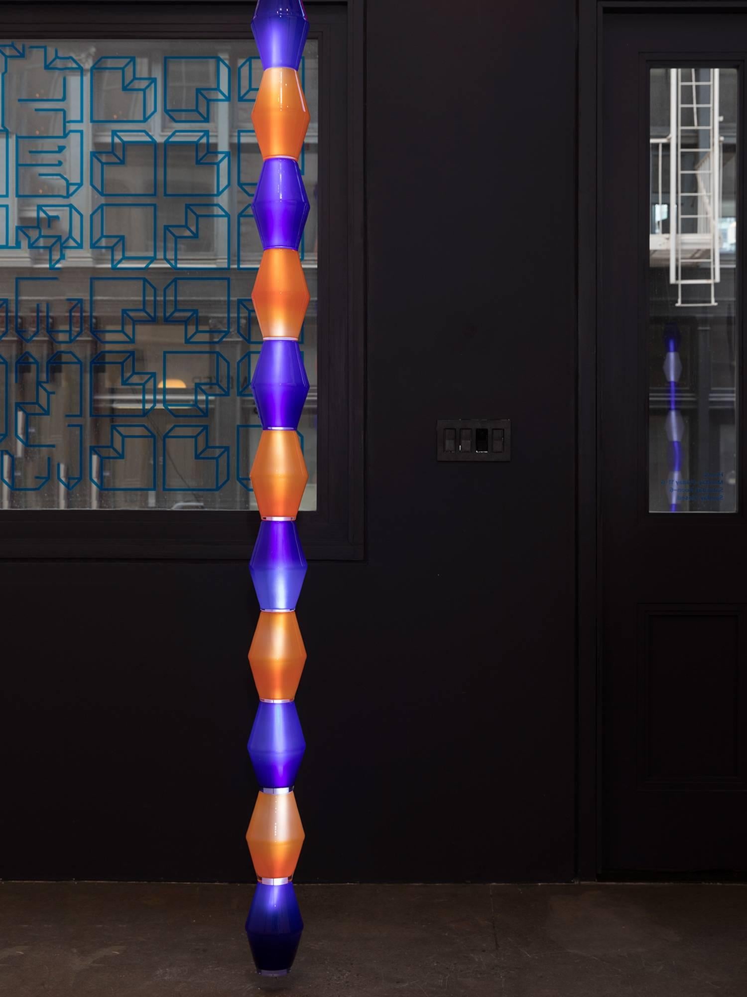 Handcrafted, totemic glass hanging light by Norwegian artist and architect Tron Meyer. The lamp is made of eleven orange and blue glass shapes strung around an LED core, which were hand-blown into a traditional wooden mold in a 200-year-old glass
