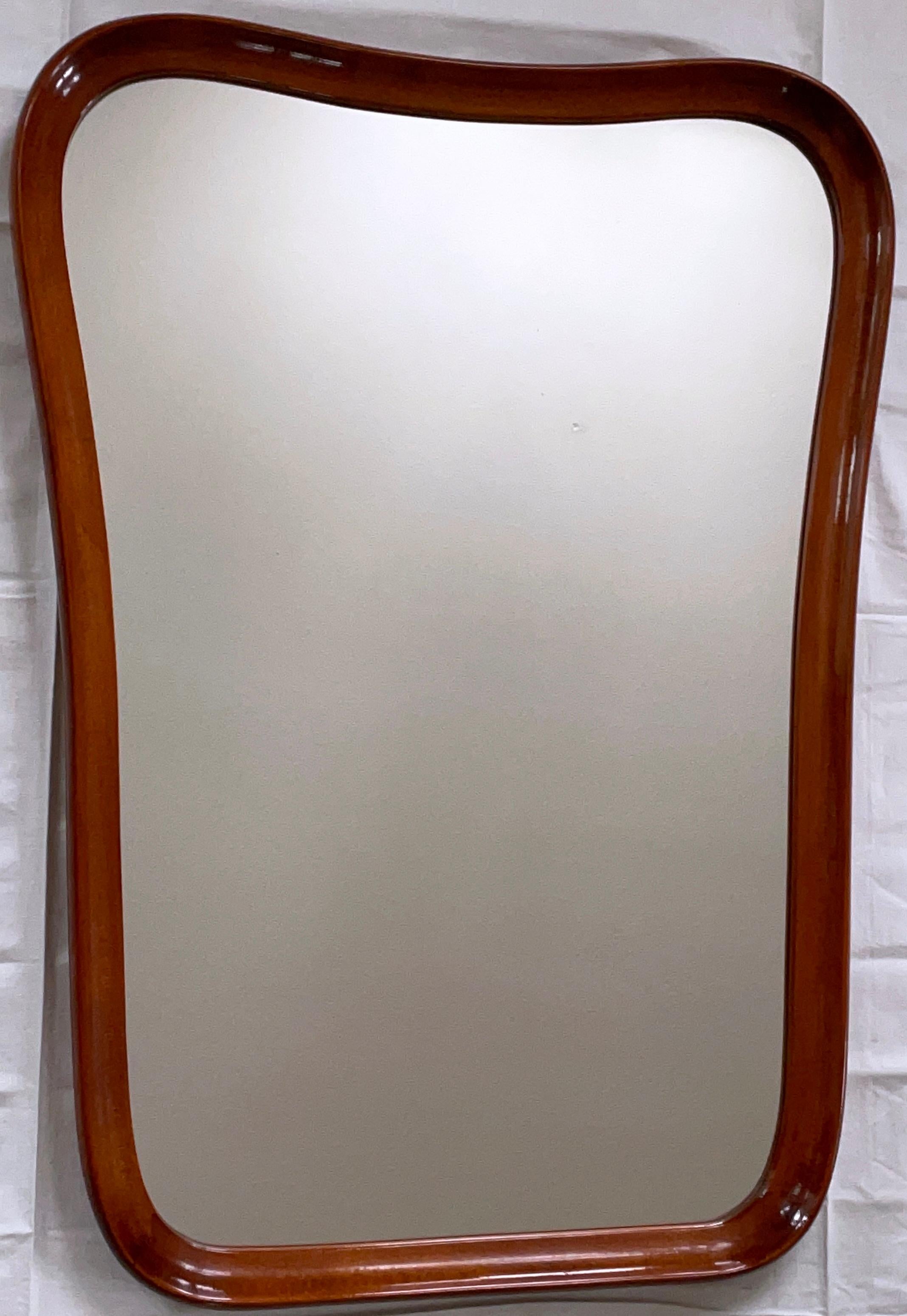 Large sculptural wall mirror produced in Sweden during the 1940s. The mirror frame is stained walnut wood and made with curvy sculptural lines. Very good vintage condition with no scratches on the glass and the frame in excellent condition.