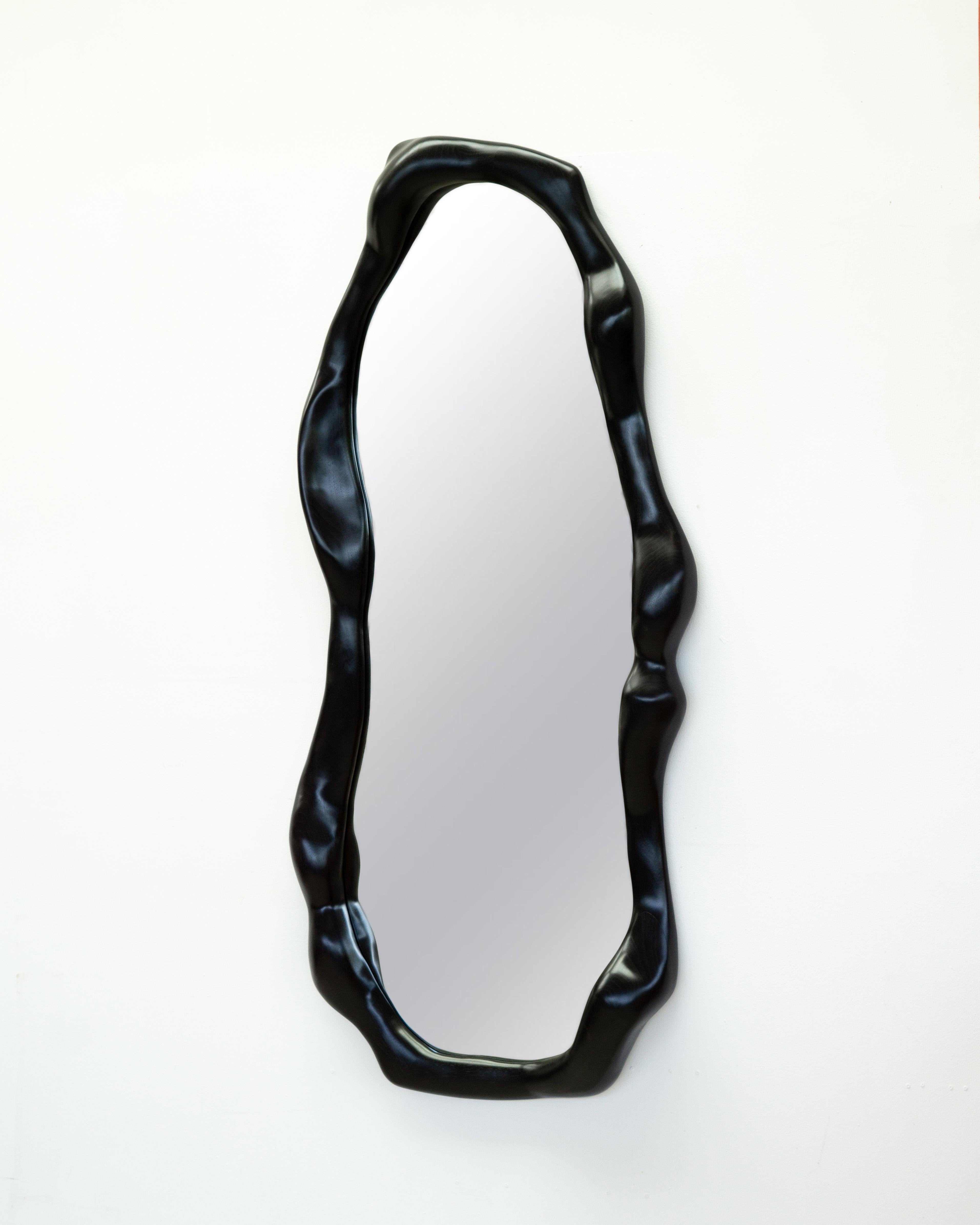 The frame of the mirror is shaped using various hand tools, making each piece unique with its own distinctive wood grain. It is made from high-quality walnut wood that has been ebonized and finished with a natural hardwax oil.

The mirror is mounted