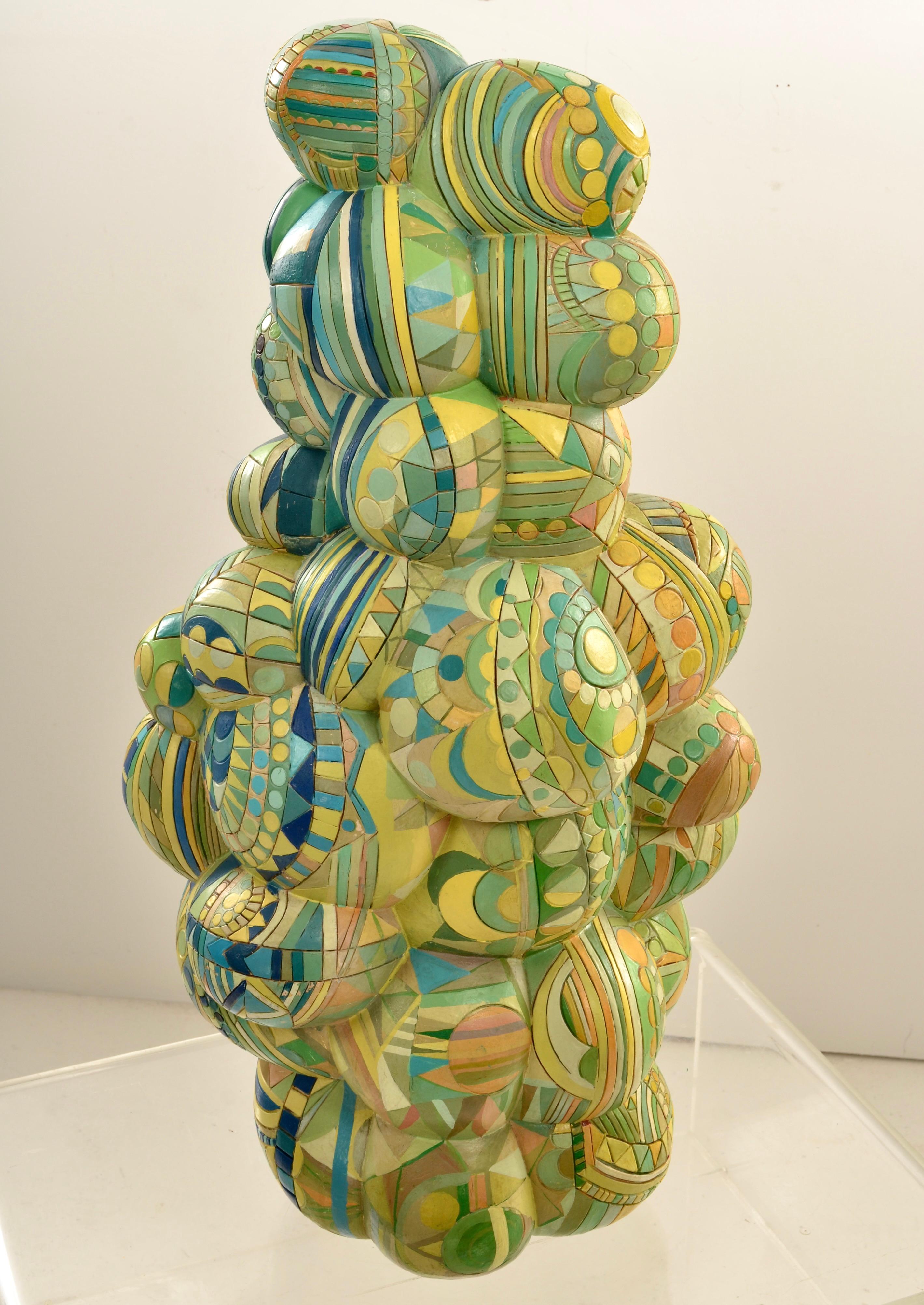 Dieses Werk des berühmten Künstlers Alexander Ney ist ein Meisterwerk der Fantasie, kunstvoll verziert mit runden und halbrunden Motiven in verschiedenen Farben.  Jede Seite der Skulptur weist ein anderes Farbthema auf und scheint ein sich