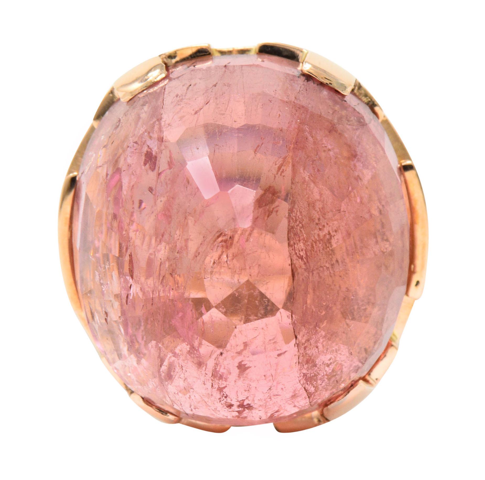 Centering a substantial checkerboard cut pink tourmaline, reverse set as a high dome, measuring approximately 26.0 x 24.0 mm

A very saturated bubble gum pink color and translucent with natural inclusions

Set by wide prongs and features a stylized
