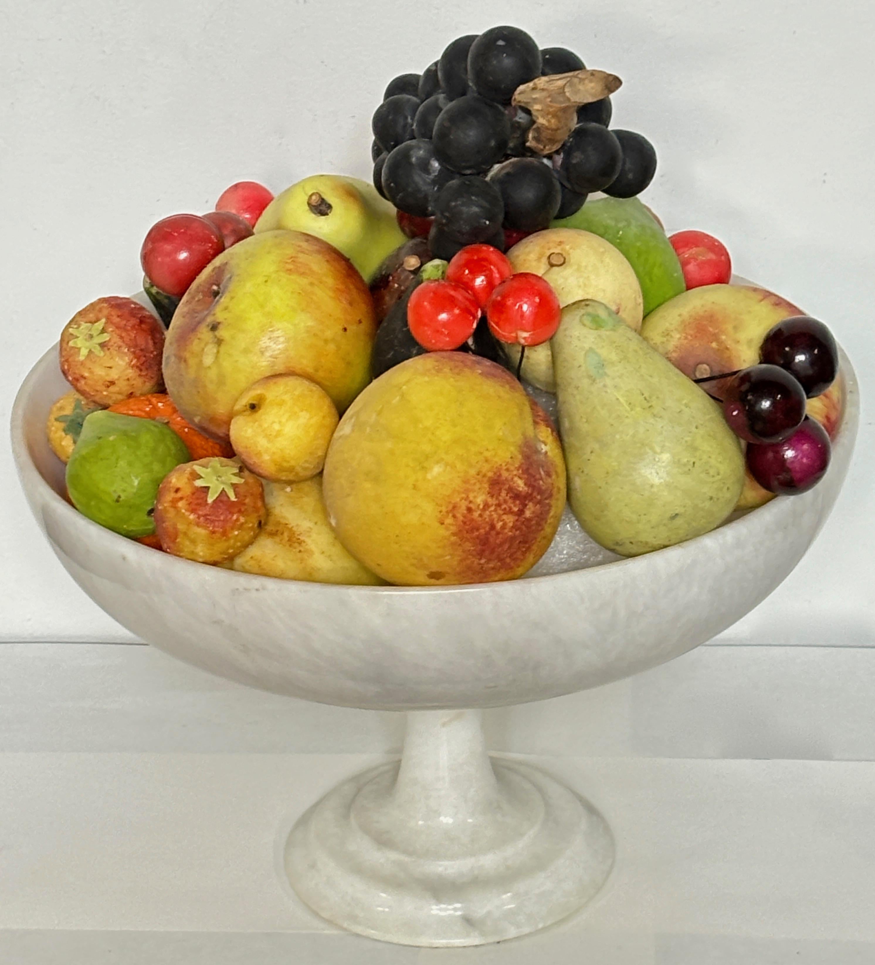 A large assortment of Italian hand carved and painted marble and alabaster fruit arranged on a round white marble compote on stand.  A total of 33 pieces with a foam ball in the center for support.  Fruit and comport in overall good original