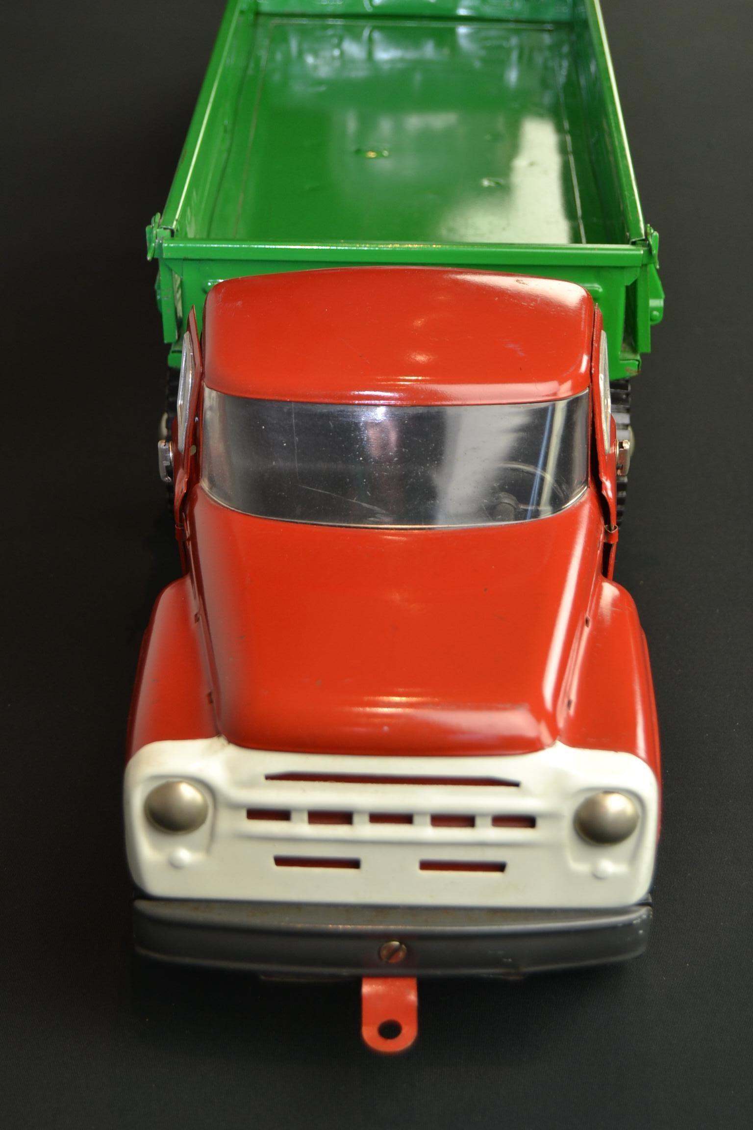 Vintage large semi-trailer truck toy. 
This large metal truck toy has a red cabin and a green trailer. The color and painting is still original. It was made in Russia in the 1990s, in 1994 which is given on the license plate. As well the flap at