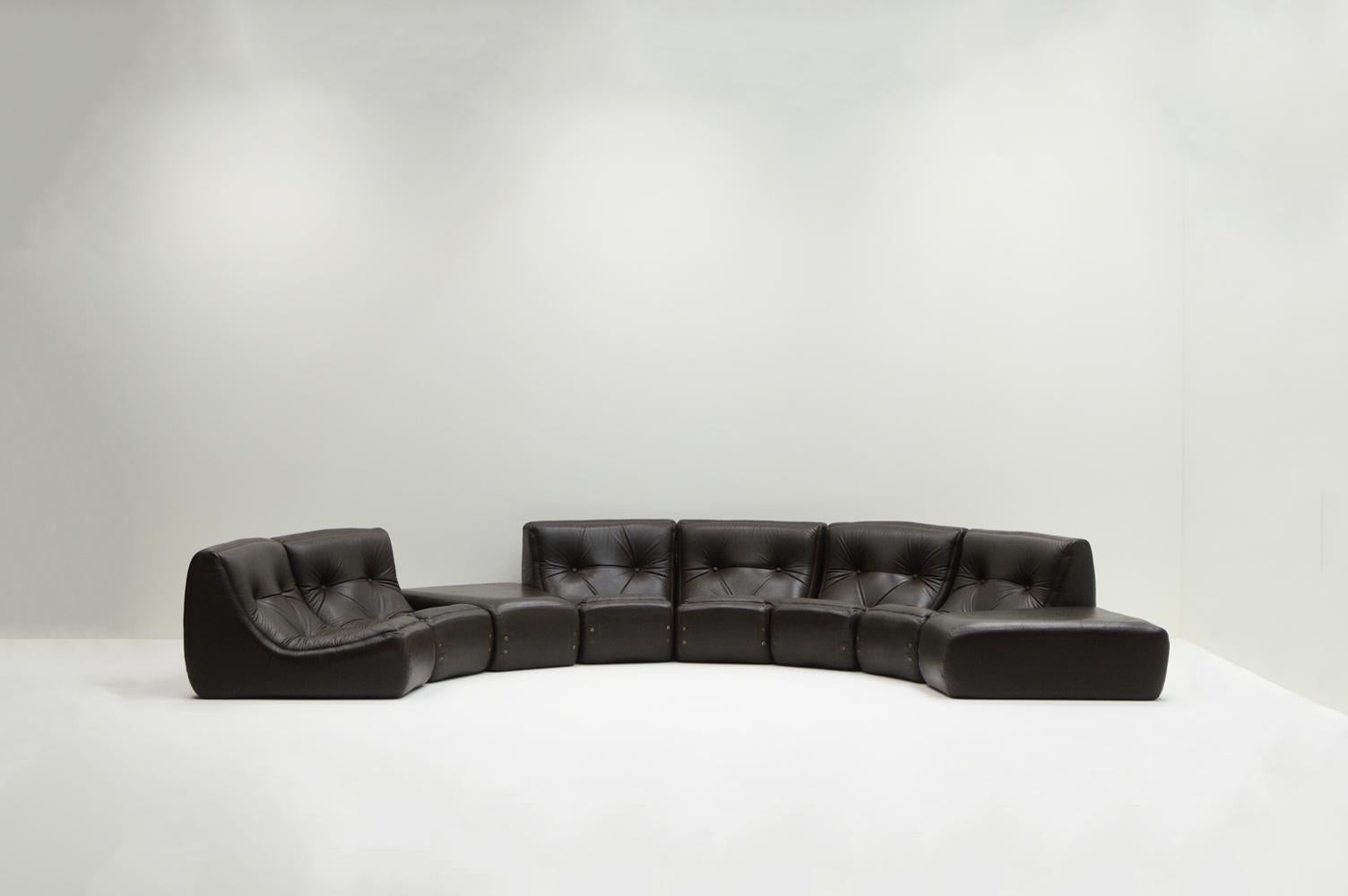Large set curved modular sofa, 1970s France. Rare sofa in the style of Michel Ducaroy. Consists of 8 curved pieces (6 seats and 2 ottoman). Original dark brow faux leather. Place them as you wish, separate or together. Low and comfortable sofa.