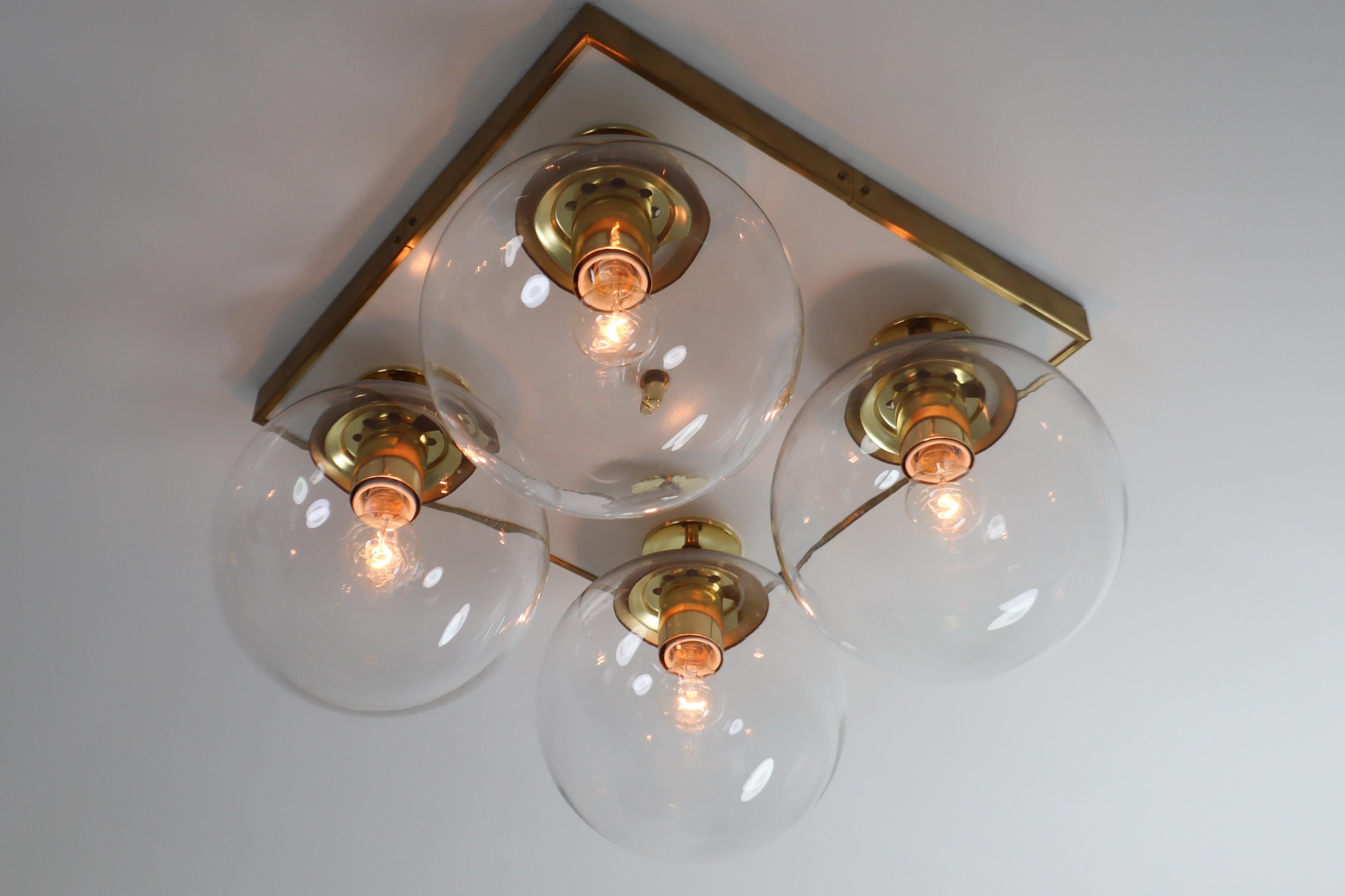 Midcentury ceiling brass chandeliers, flushmounts by designer and manufacturer Preciosa and produced in Czech Republic the early 1970s. Beautiful work with four transparent blown spheres by a brass structure. The light created by these chandeliers