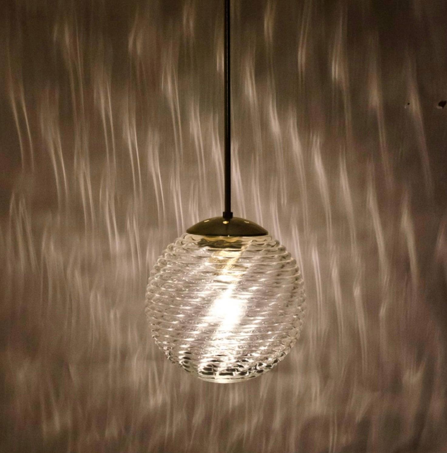 Wonderful ceiling lamps with glass bowl or spheres mounted to a brass element. The glass has pattern in it, what gives a nice diffuse light effect and a nice pattern on ceiling, walls and floor. The brass parts are nicely shaped. The pleasant light