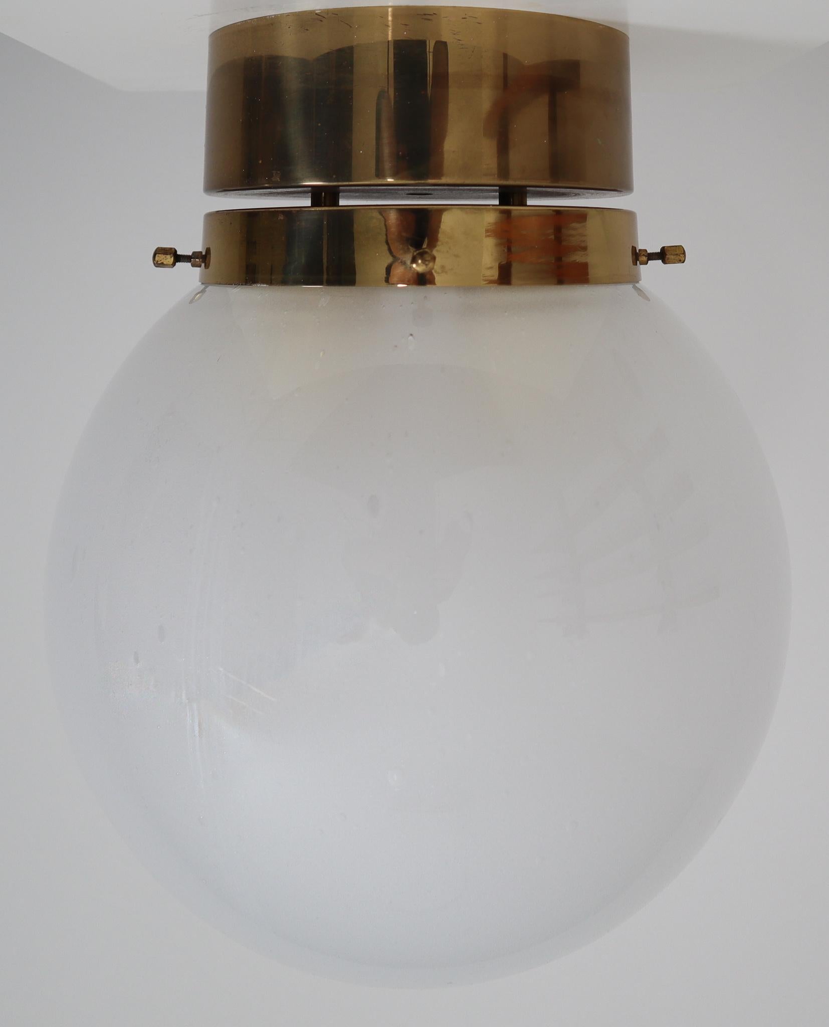 Midcentury hotel ceiling or floor lights with brass frame and large hand blown white frosted glass globes. The lights are beautifully thanks to the hand blown glass. The pleasant light it spreads is very atmospheric, these lights will contribute to