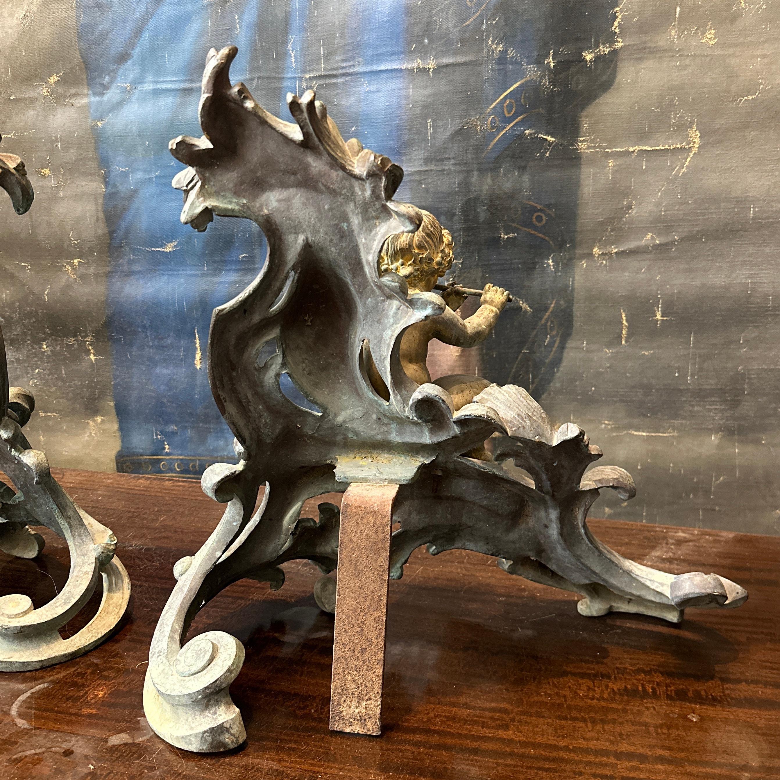 Elevate your fireplace with this beautiful pair of 19th-century French bronze chenets. Showcasing exceptional artistry, each chenet features a beautifully detailed faun—one playing the flute and the other holding a baton—resting against ornate