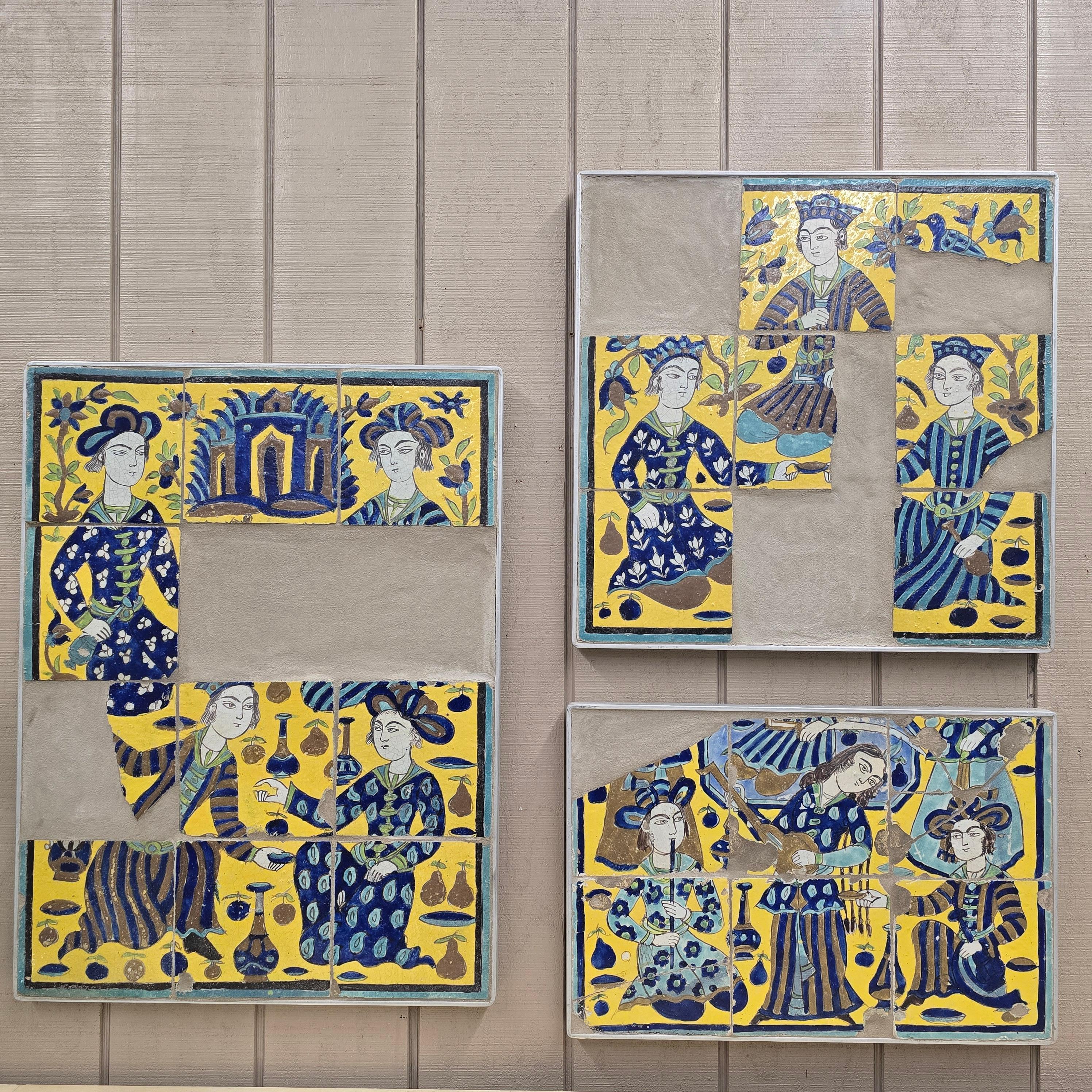 A rare and unusually large surviving group of Qajar dynasty tiles (19th century, Persia/Iran), richly decorated in cobalt blue, turquoise, ochre yellow, and manganese. The tiles depict courtly scenes of elegantly dressed figures, attendants, and