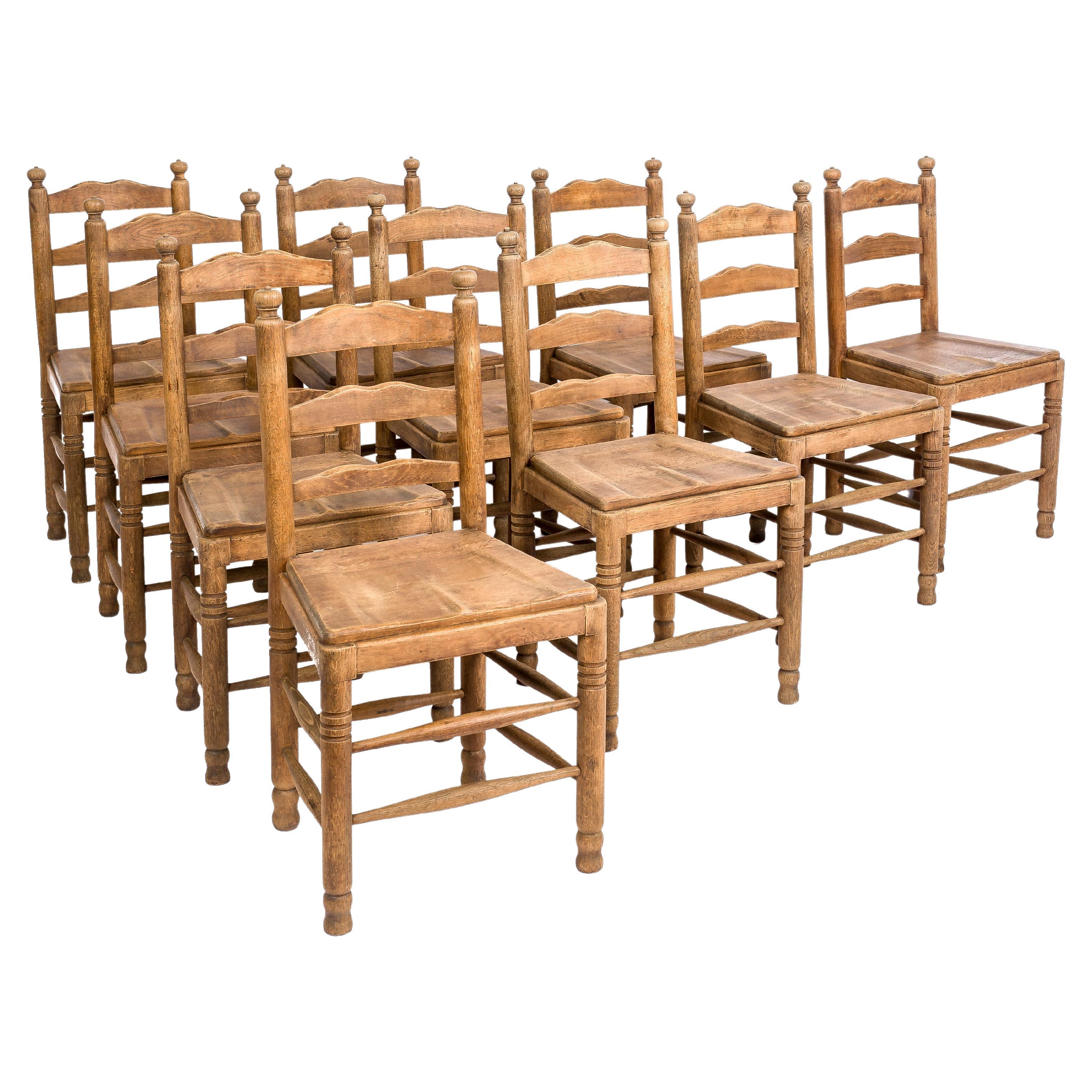 A beautiful large set of 10 dining chairs that originate in a Northern French monastery. 
The chairs were made in the finest quality European summer oak in the late 1800s. The set presented here has 10 chairs, but we have 42 pieces available. The