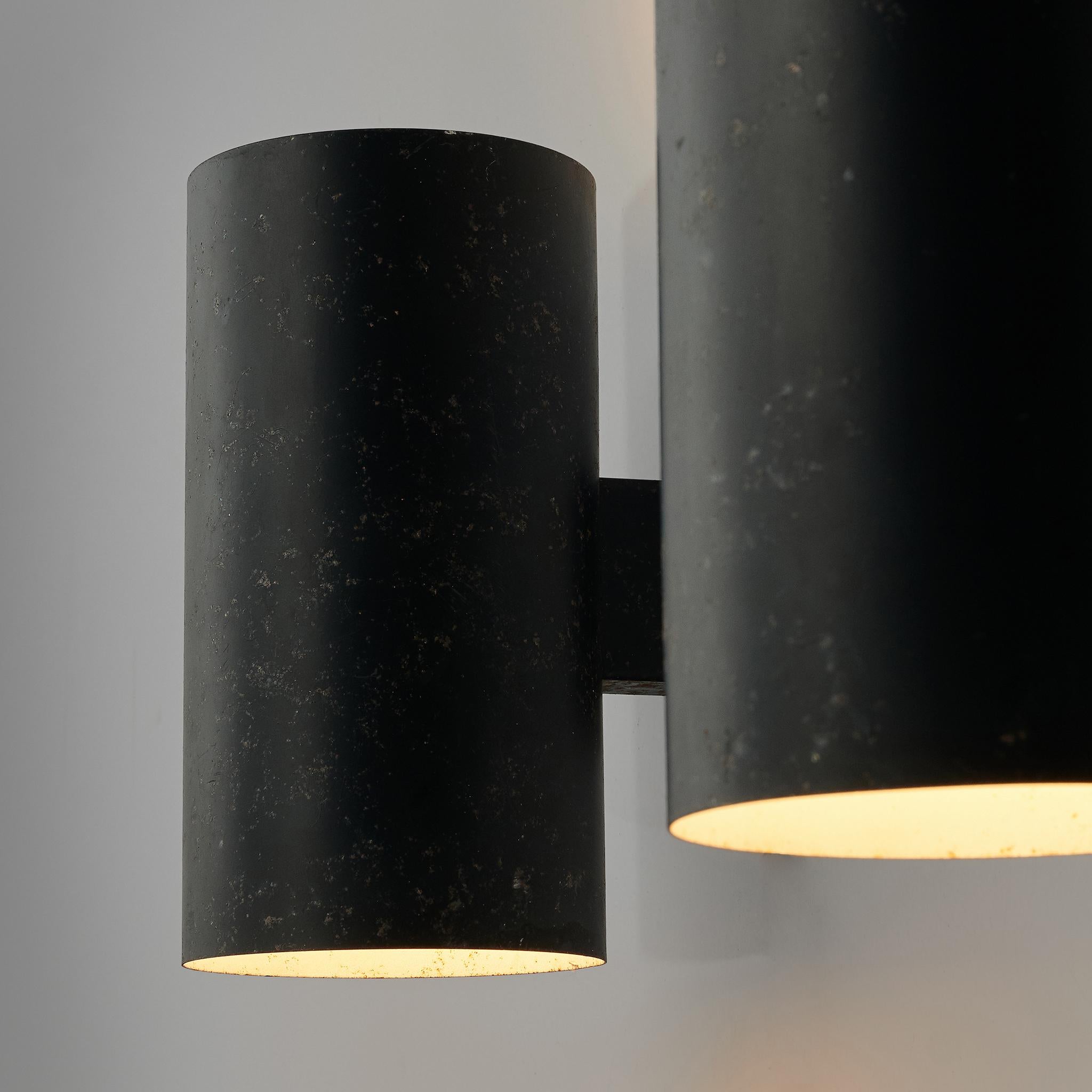 Louis Poulsen, wall lamps, lacquered metal, Denmark, 1950s. 

Wall lights by manufacturer Louis Poulsen. The lights have a strong simple shape. The blak metal cones have a beautiful patina. Because of the cylindrical shape of the lamp, and the