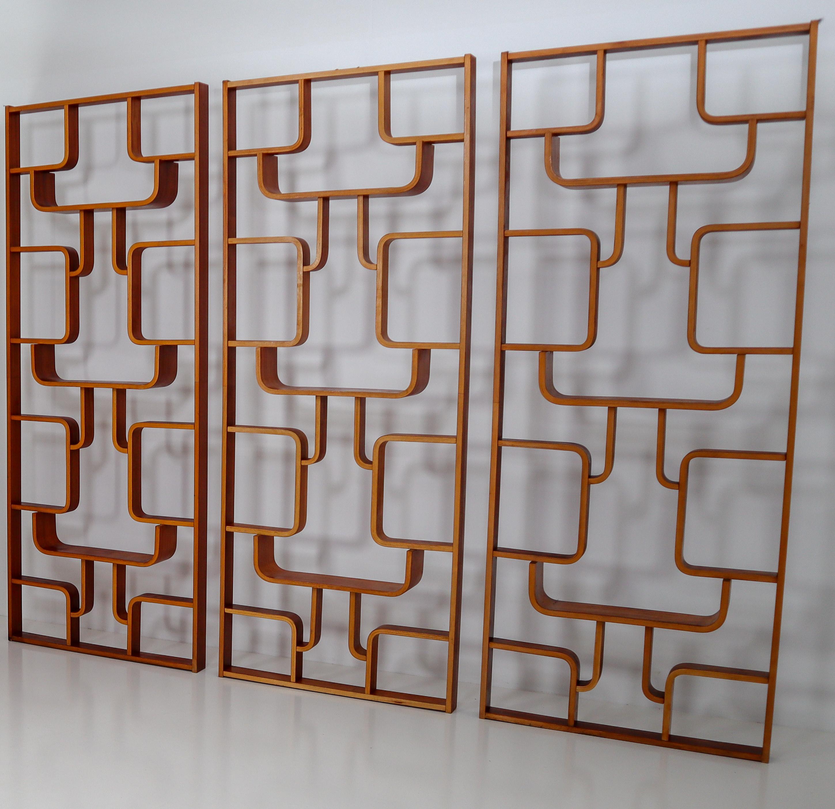 A large set of room dividers from a hotel from Prague purchased from the original owners. These objects can be used as a wall-mounted shelving unit or room divider. Square edges in mahogany color plywood and features geometric patterns. Designed by