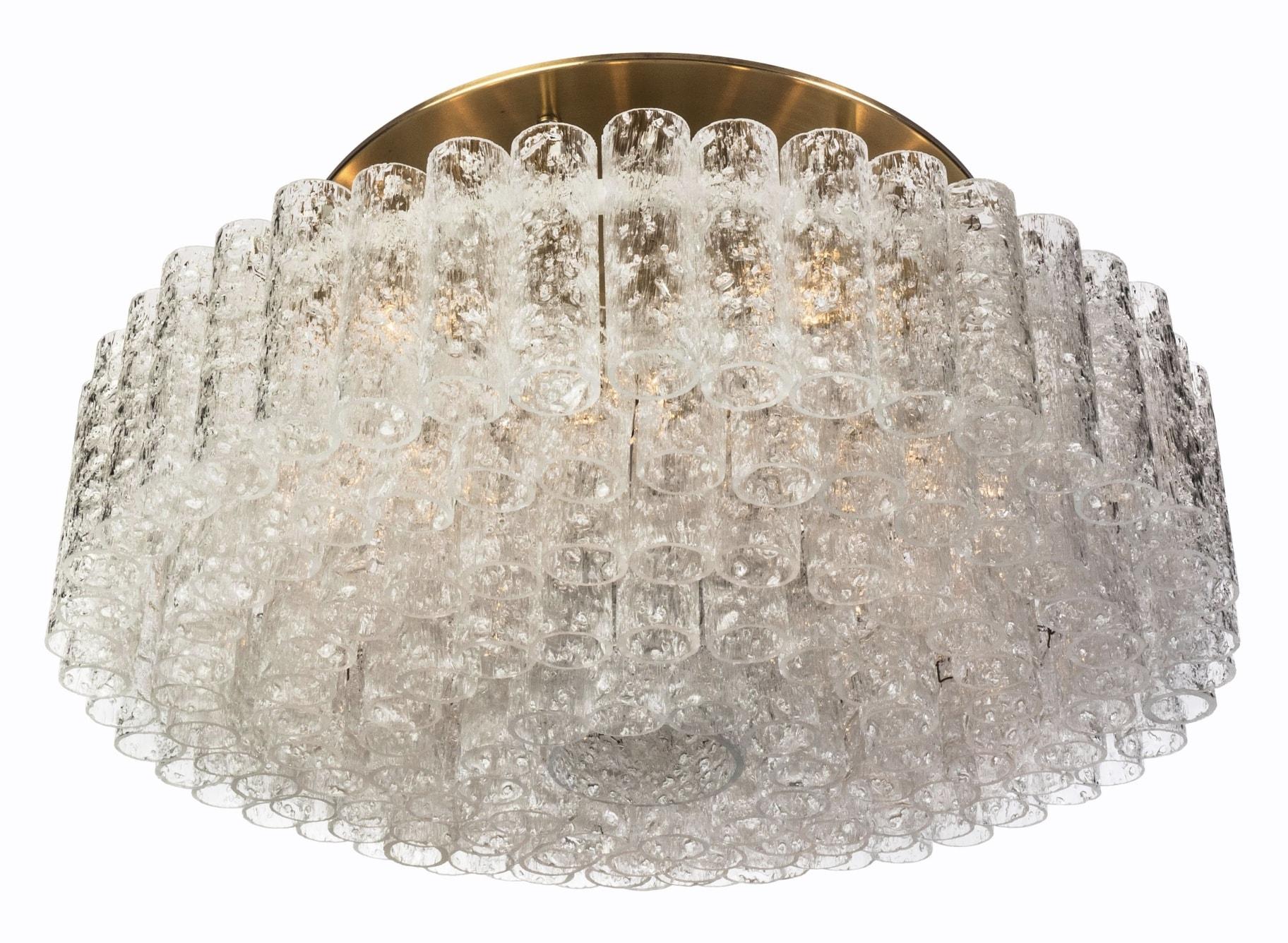 Set of 12 (XL-size) gorgeous, 1950s Mid-Century Modernist flush mount chandeliers was designed by Doria Leuchten, Germany. It features multi-tiered layers of textured ice glass tubes connected to a circular brushed brass frame. The flush mount with