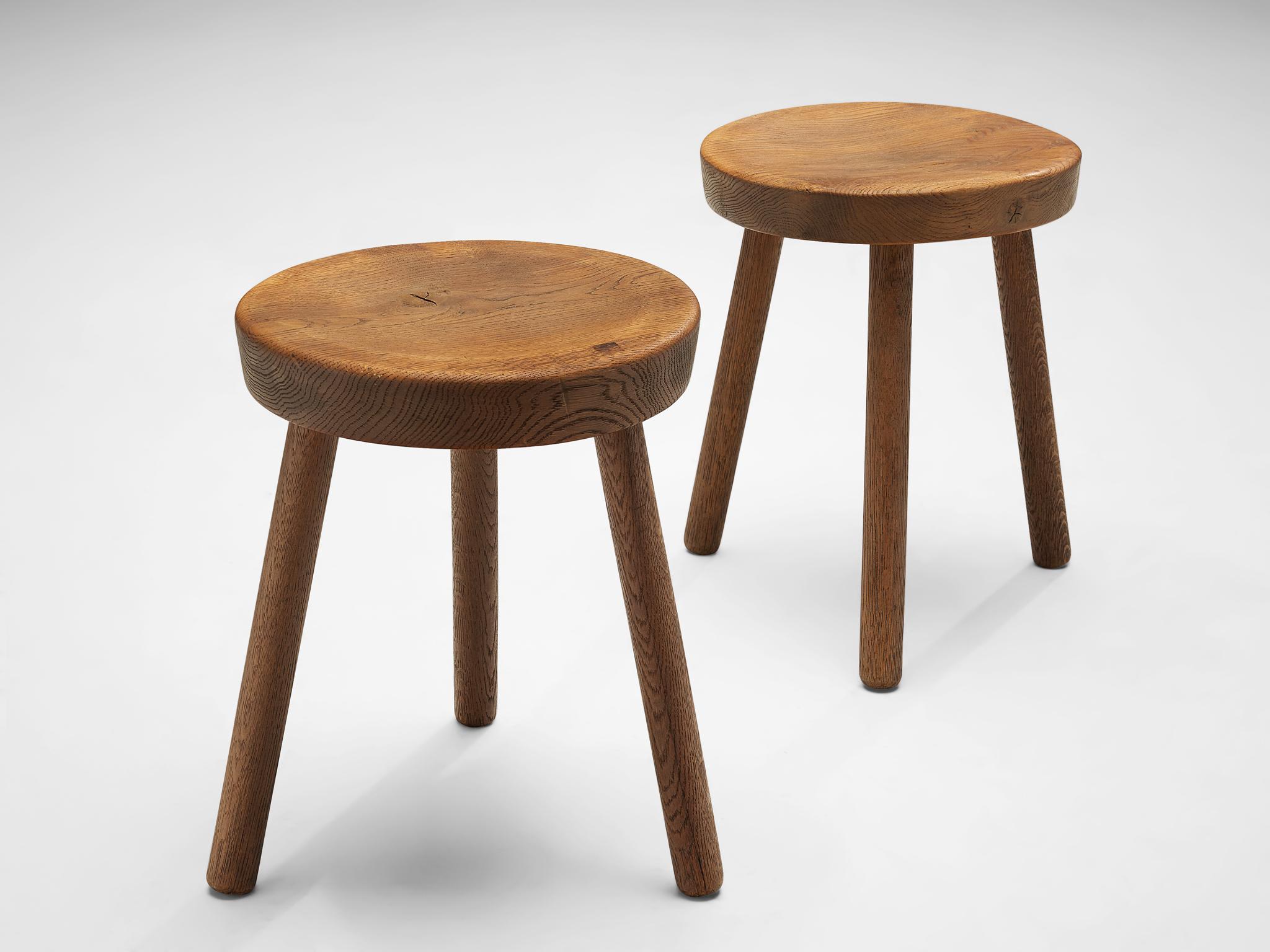 Large set of tripod stools or side tables, solid oak, Switzerland, 1960s-1970s.

Beautiful crafted oak stools originating from the exhibition center in St. Gallen, Switzerland. The seat is handcrafted to have a small dip for better comfort.  Great